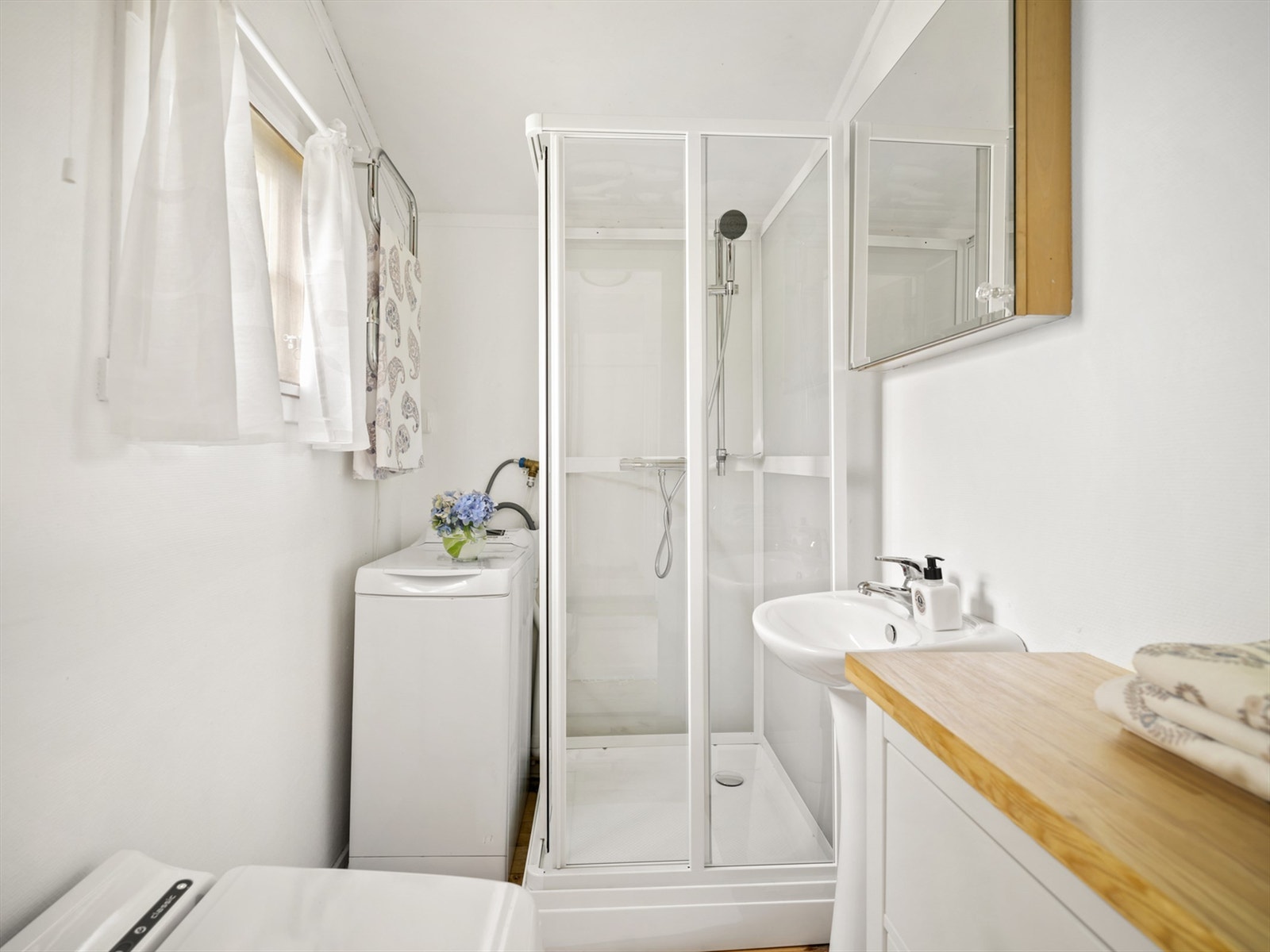 Toalettrom med forbrenningsdo, servant og opplegg for vaskemaskin. Dusjkabinett fra 2024. Galleribilde