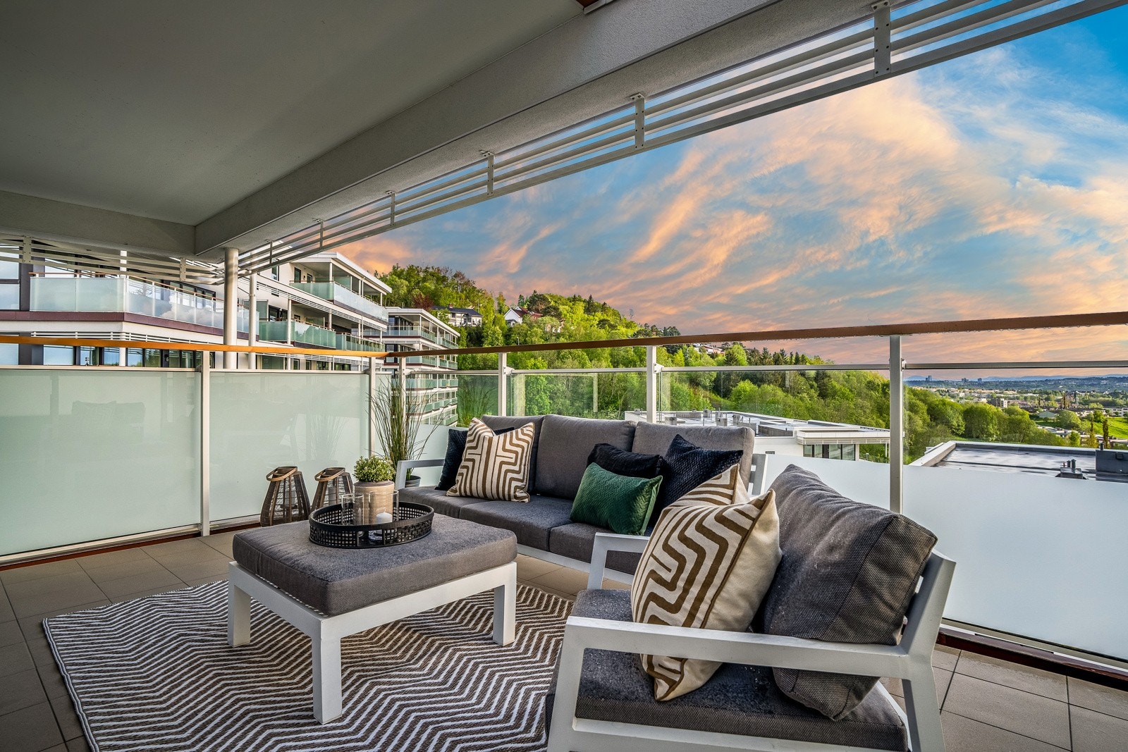 Balkongen har flislagt dekke, overbygg og rekkverk med delvis frostet glass med klar åpning øverst for å nyte utsikten fra solstolen. Galleribilde