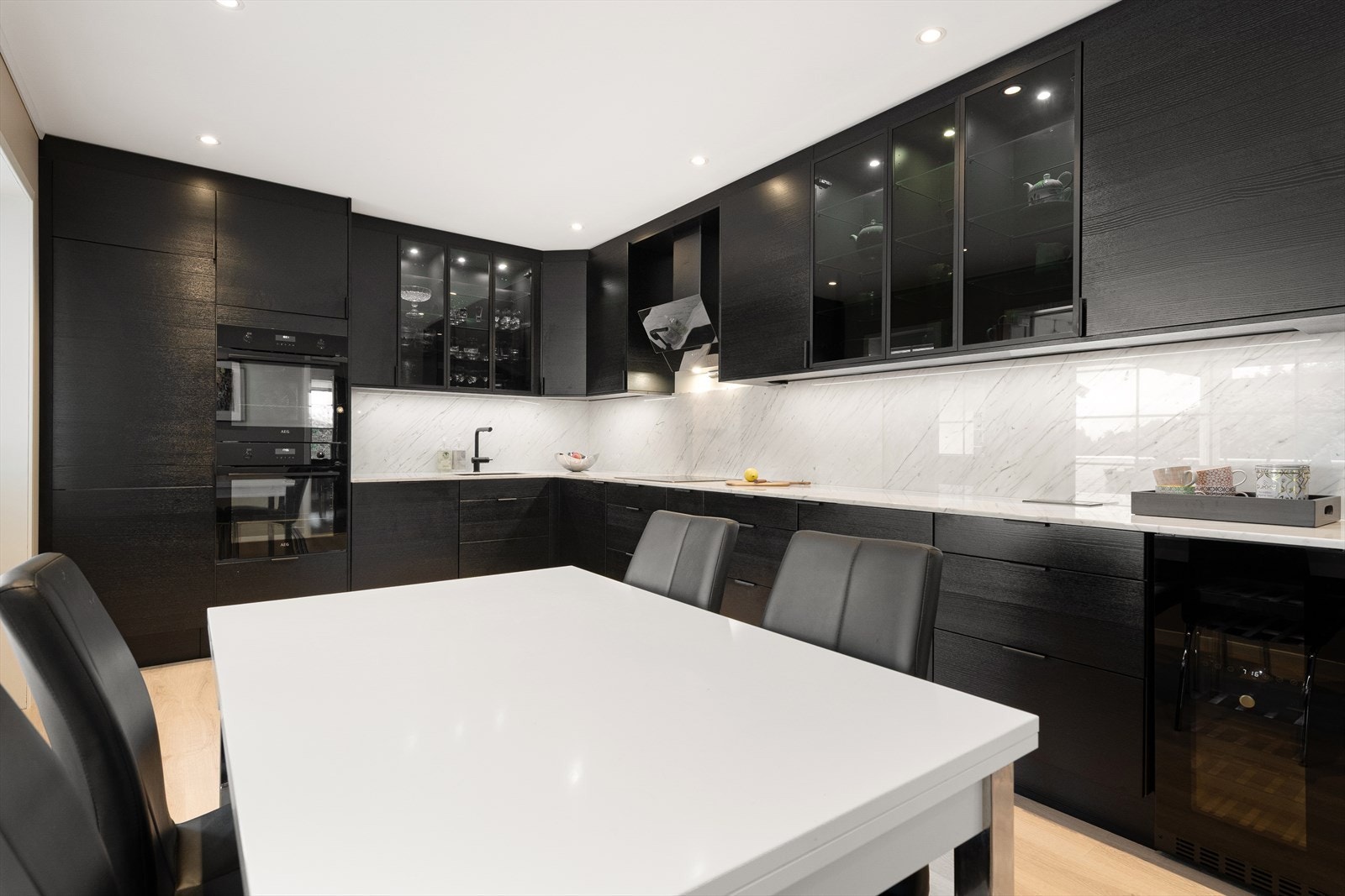 Kjøkken med nyere kjøkkeninnredning. Innredningen har rikelig med benkeplass og integrerte hvitevarer. Kjøl/frys, stekovn, koketopp, micro, oppvaskmaskin og vinskap. Galleribilde