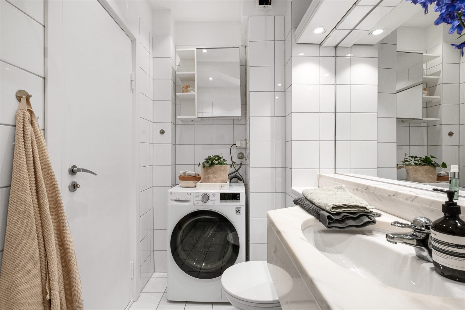 Det er elektrisk gulvvarme og nedfelt eksklusiv marmorservant i skapinnredning. Fine løsninger og opplegg for vaskemaskin / tørketrommel. Galleribilde