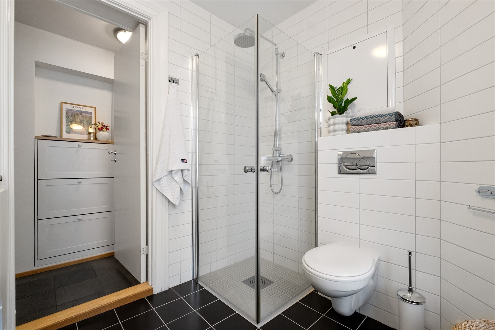 Innredet med vegghengt klosett, servant på innredning og dusjhjørne med svingbare glassdører. Opplegg for vaskemaskin. Elektrisk styrt vifte Galleribilde