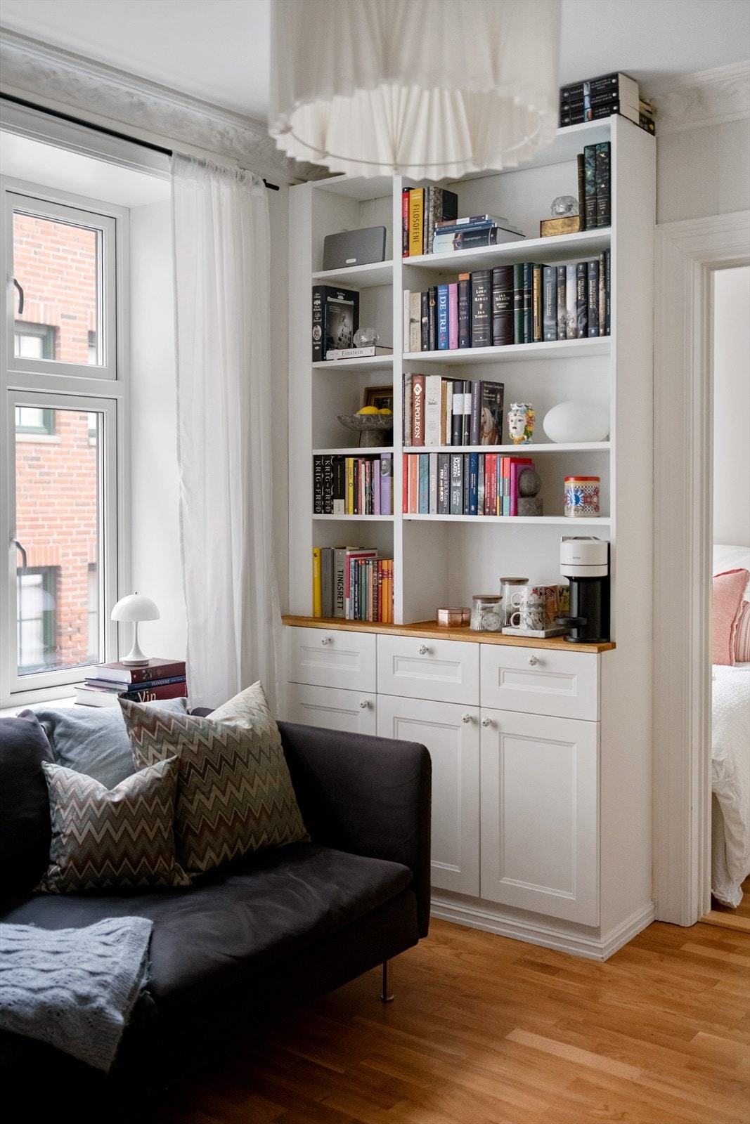 Fin og praktisk plassbygget bokhylle i stuen Galleribilde