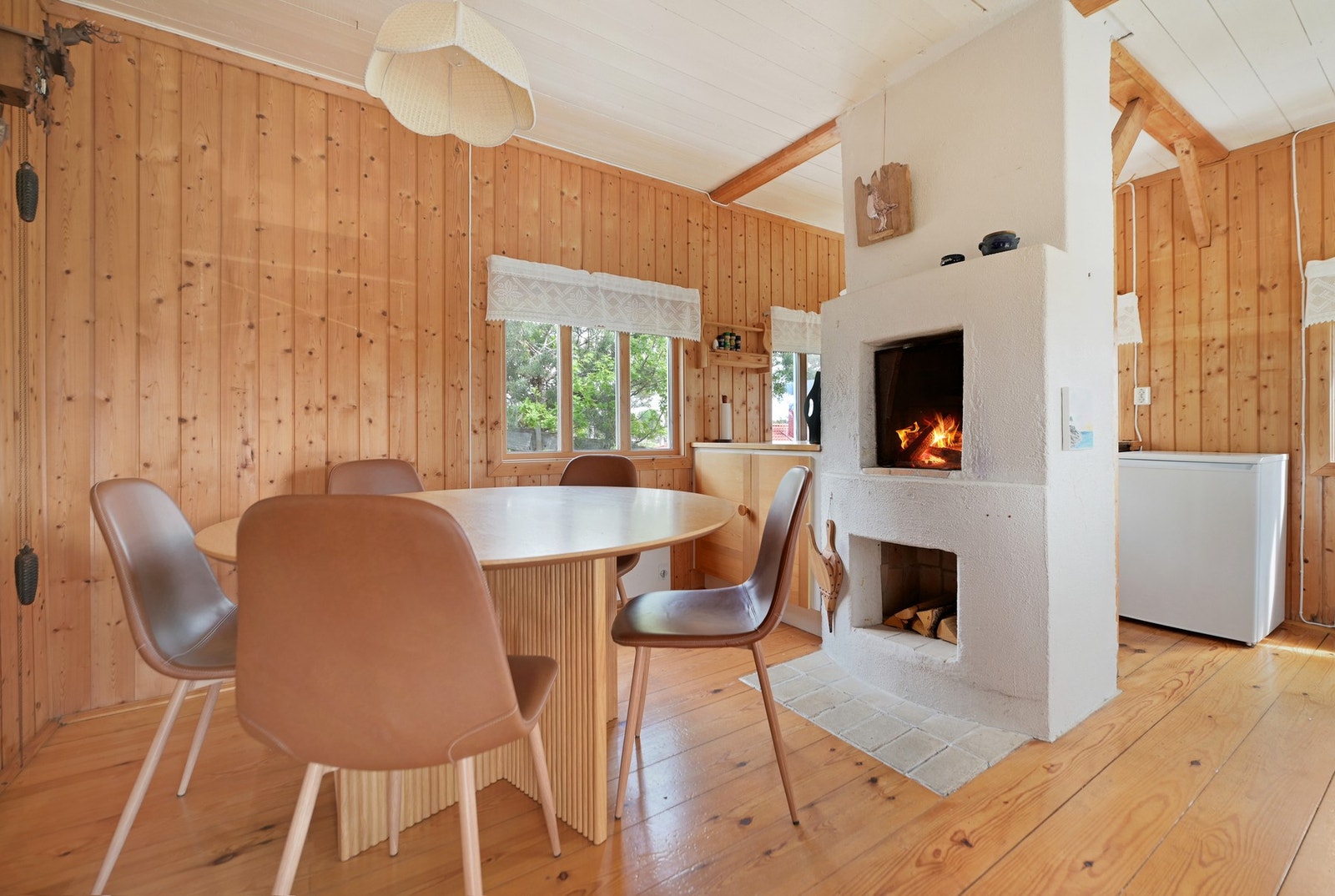 Midt i rommet står en åpen peis, som både skaper stemning og varmer godt på kalde høstkvelder. Galleribilde