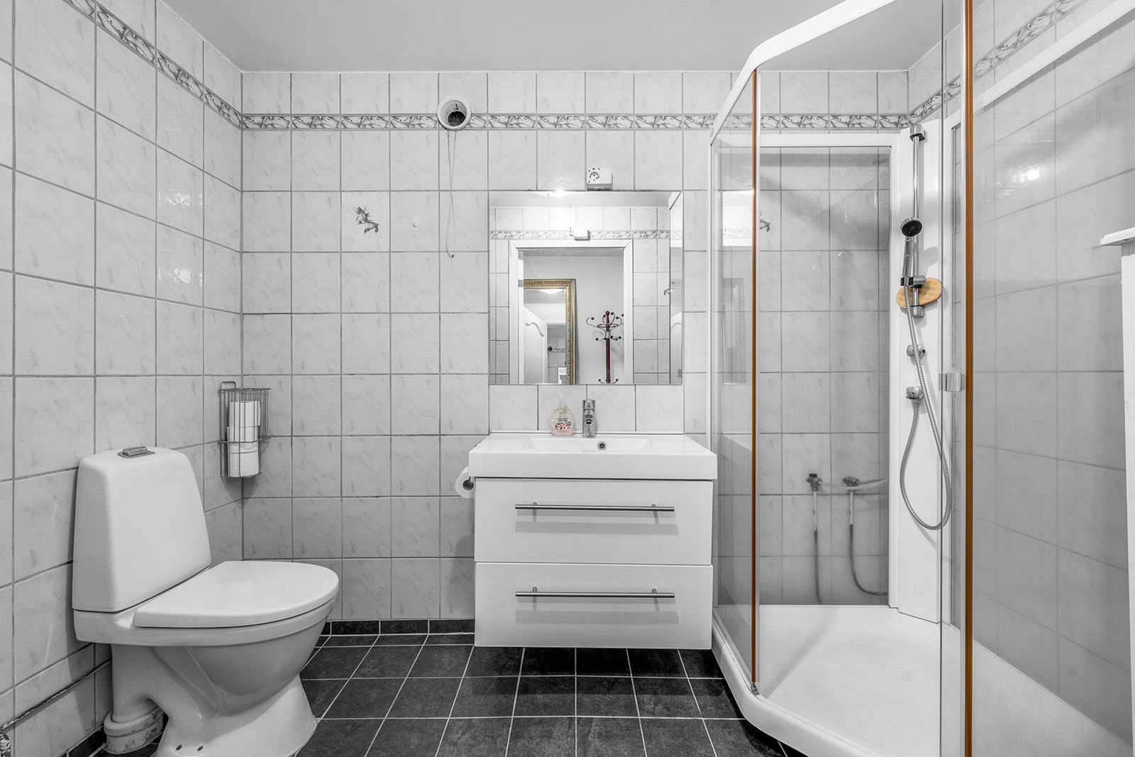 Lyst bad med flislagte gulv og vegger samt malt himling. Ifølge eier ble gulv og tak malt/oppgradert i 2018, og sanitærutstyret er delvis oppgradert i senere år - klosett fra 2020, dusjkabinett og servantinnredning fra 2018 Galleribilde