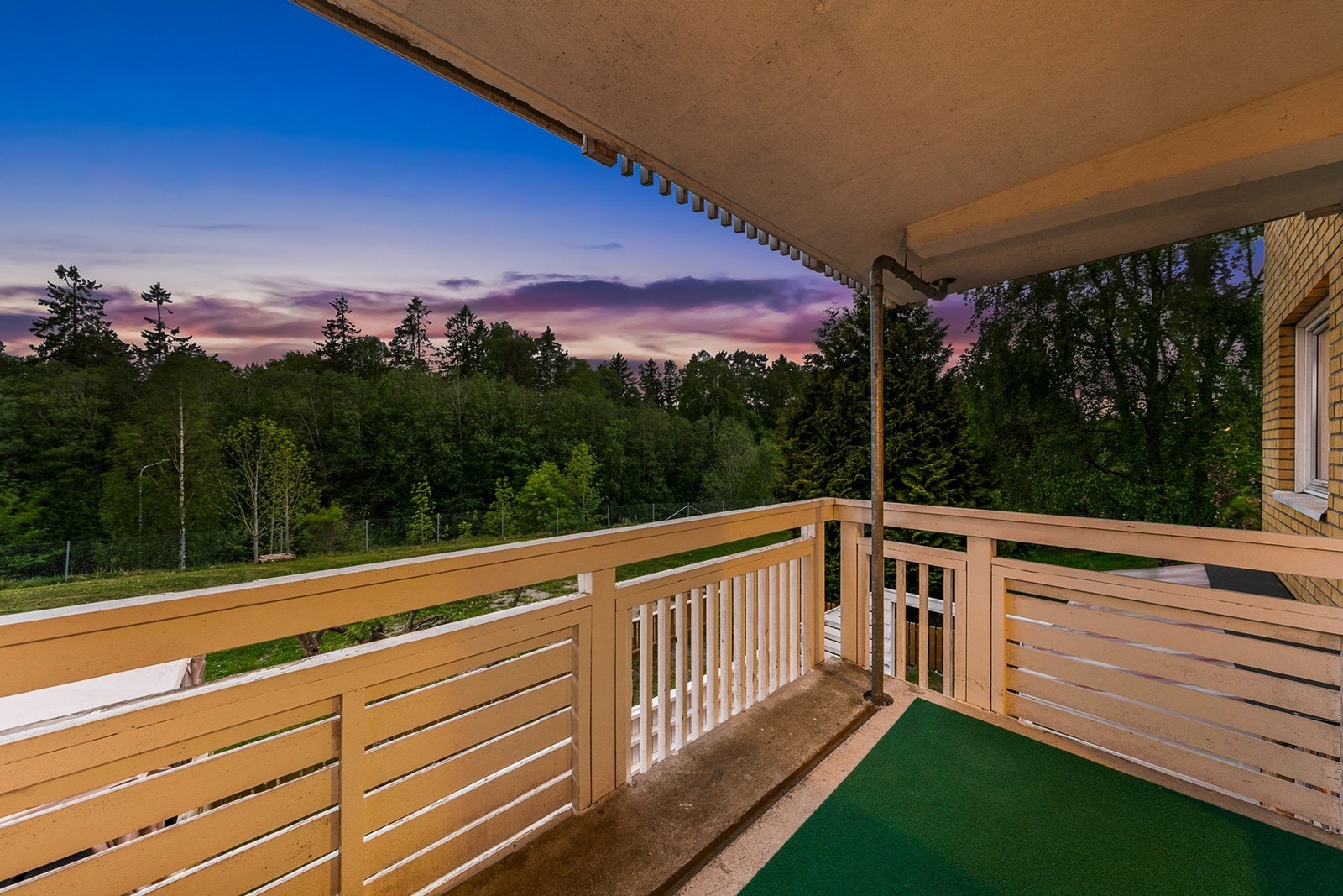 Fra soverommet har du adgang til en herlig balkong med teppe på gulv og rekkverk i trekonstruksjon. Her har du plass til hyggelig utebord med stoler, grønne planter og annet ønsket interiør Galleribilde