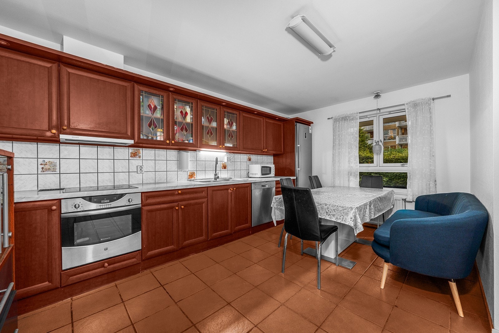 Praktisk utforming med nisjer til kjøl/fryseskap, oppvaskmaskin, platetopp og stekeovn. Det er flislagt mellom benkeplate og overskap, noe som gir et rent og stilfullt uttrykk samt beskytter veggen Galleribilde