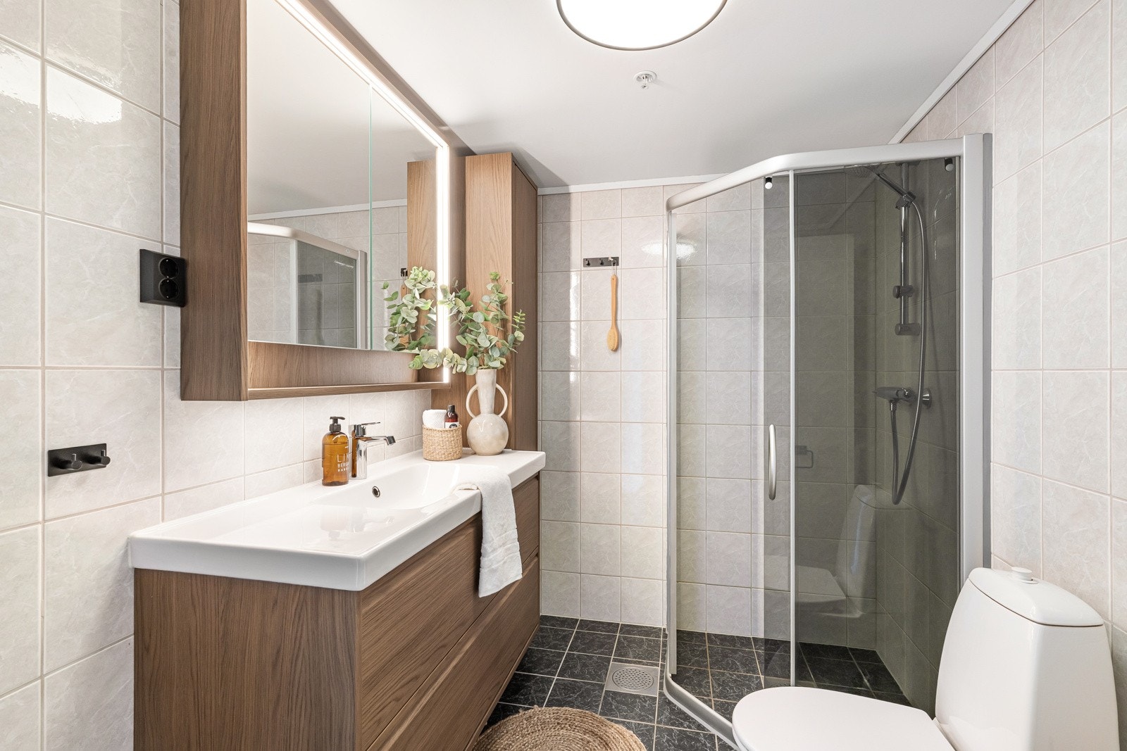 Badet er helfliset og er innredet med nedfelt servant, toalett og dusjhjørne. Flott og moderne badromsinnredning. Galleribilde