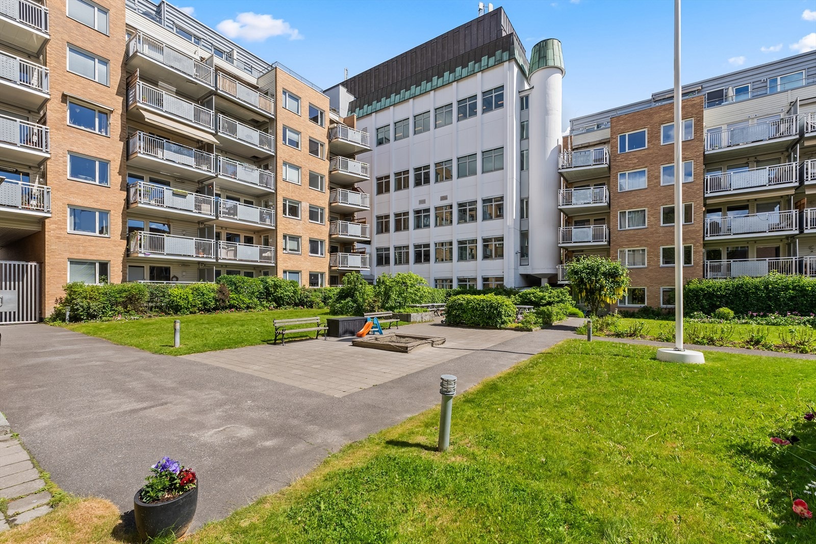 Innbydende fellesområder med beplantning og møblerte soner skaper et trivelig nærmiljø i sameiet Galleribilde