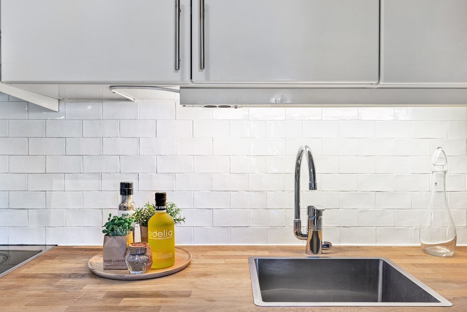 Fliser og integrert belysning over benkeplaten gir både funksjonalitet og et stilrent uttrykk. Galleribilde