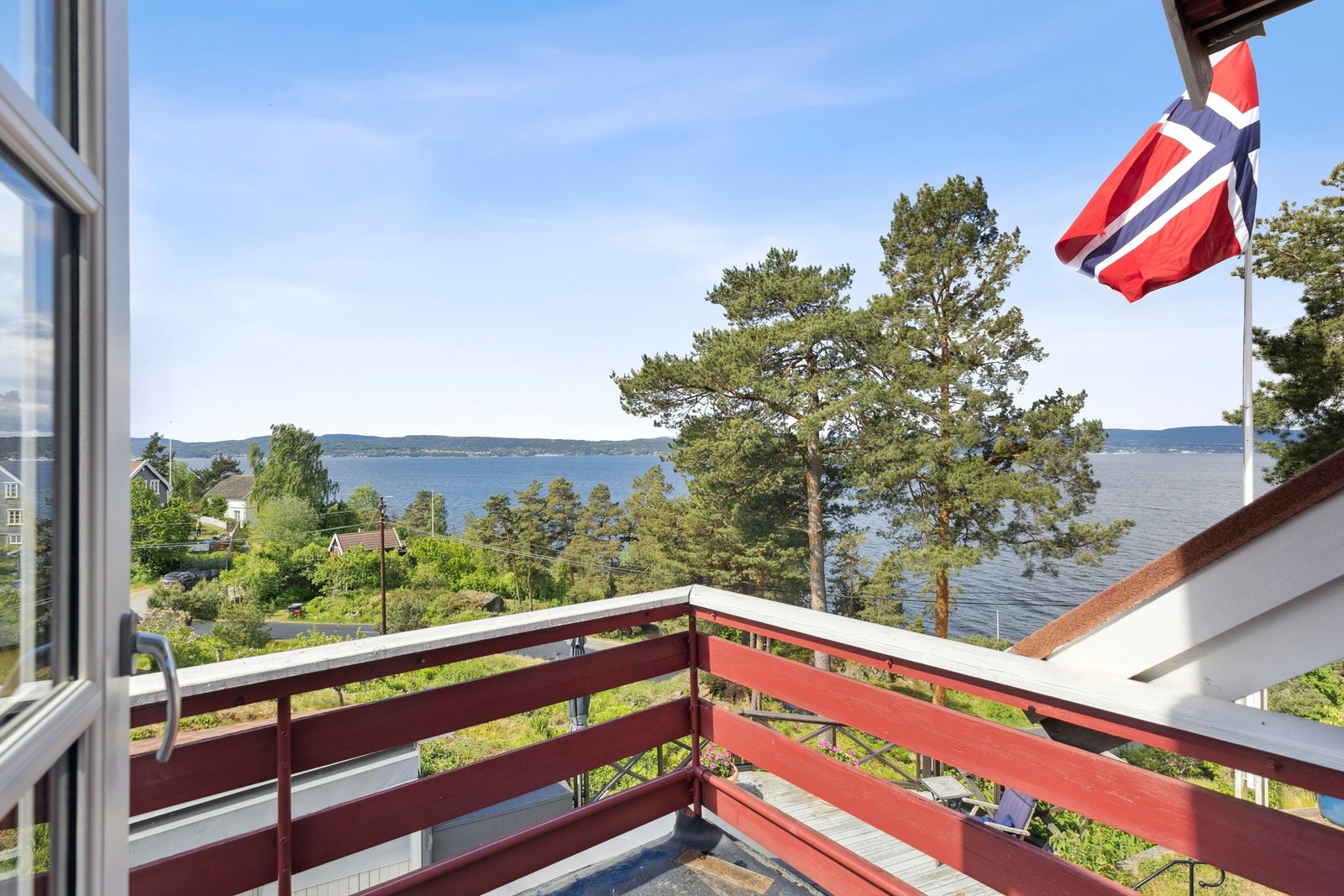 Utgang fra hovedsoverom til sydvestvendt balkong med vidstrakt utsikt mot fjorden Galleribilde