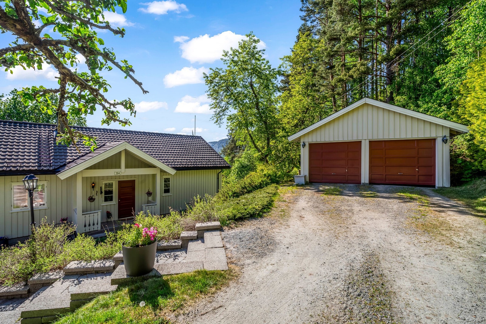 Garasje med to løp. I tillegg er det en enkel carport på andre siden av innkjøringen til tunet. Galleribilde