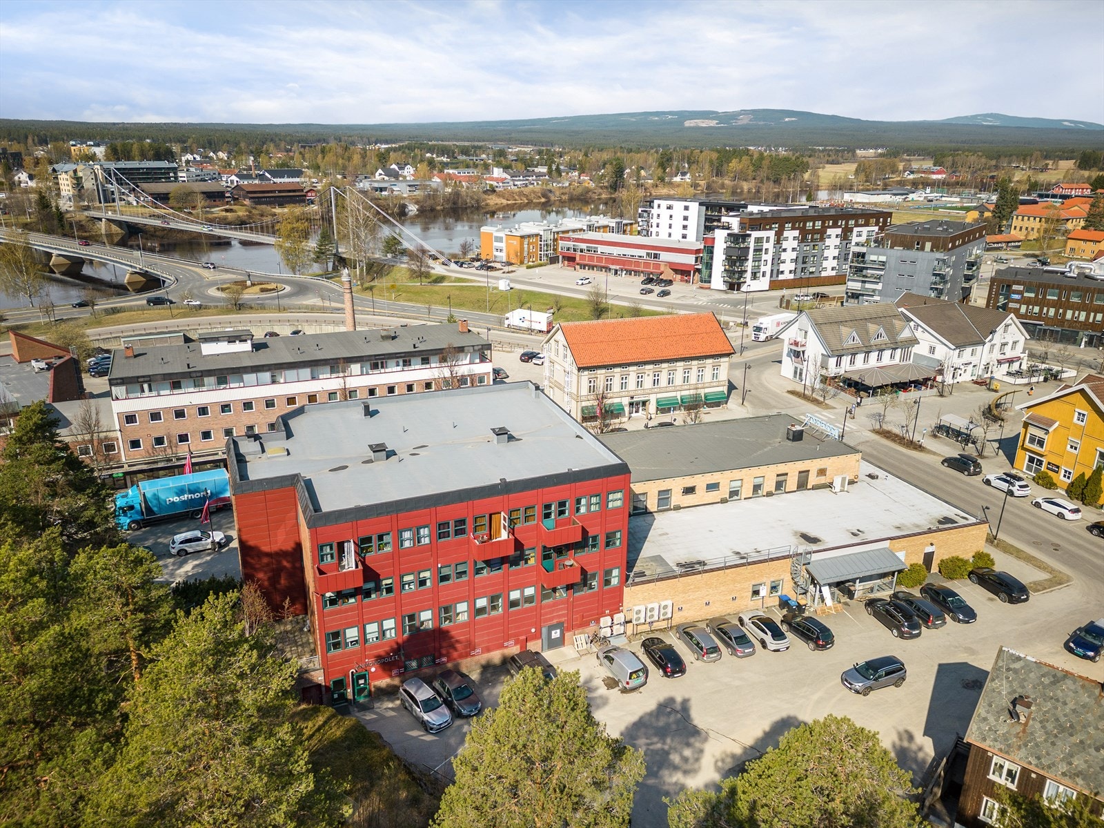 Bildet viser bygget fra baksiden med parkering. i bakgrunn synes rundkjøringen hvor rv. 2 (Skarnes/Elverum) og rv. 25 (Trysil/Hamar) møtes. Galleribilde