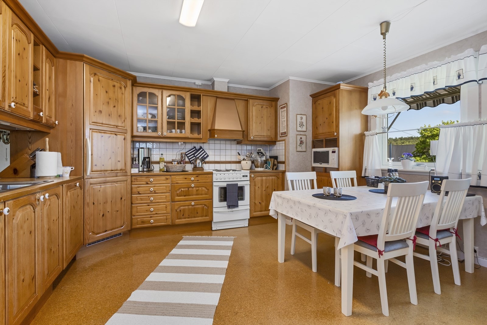 Kjøkkenet i kårboligen har godt med oppbevaring og plass for spisebord med utsyn over tunet. Galleribilde