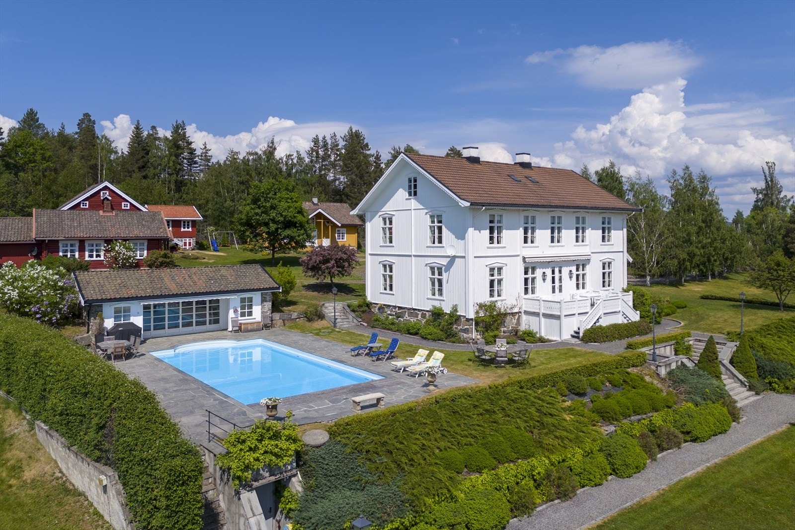 I enden av bassenget ligger bassenghuset som er innredet med stue, kjøkken, dusj, wc og lagerrom Galleribilde