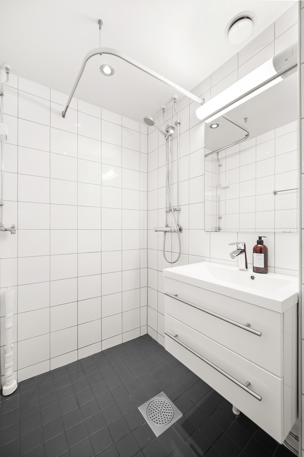 Tidløst, pent bad med flislagte overflater, elektrisk gulvvarme og innfelte downlights i himling. Det er opplegg for vaskemaskin. Galleribilde