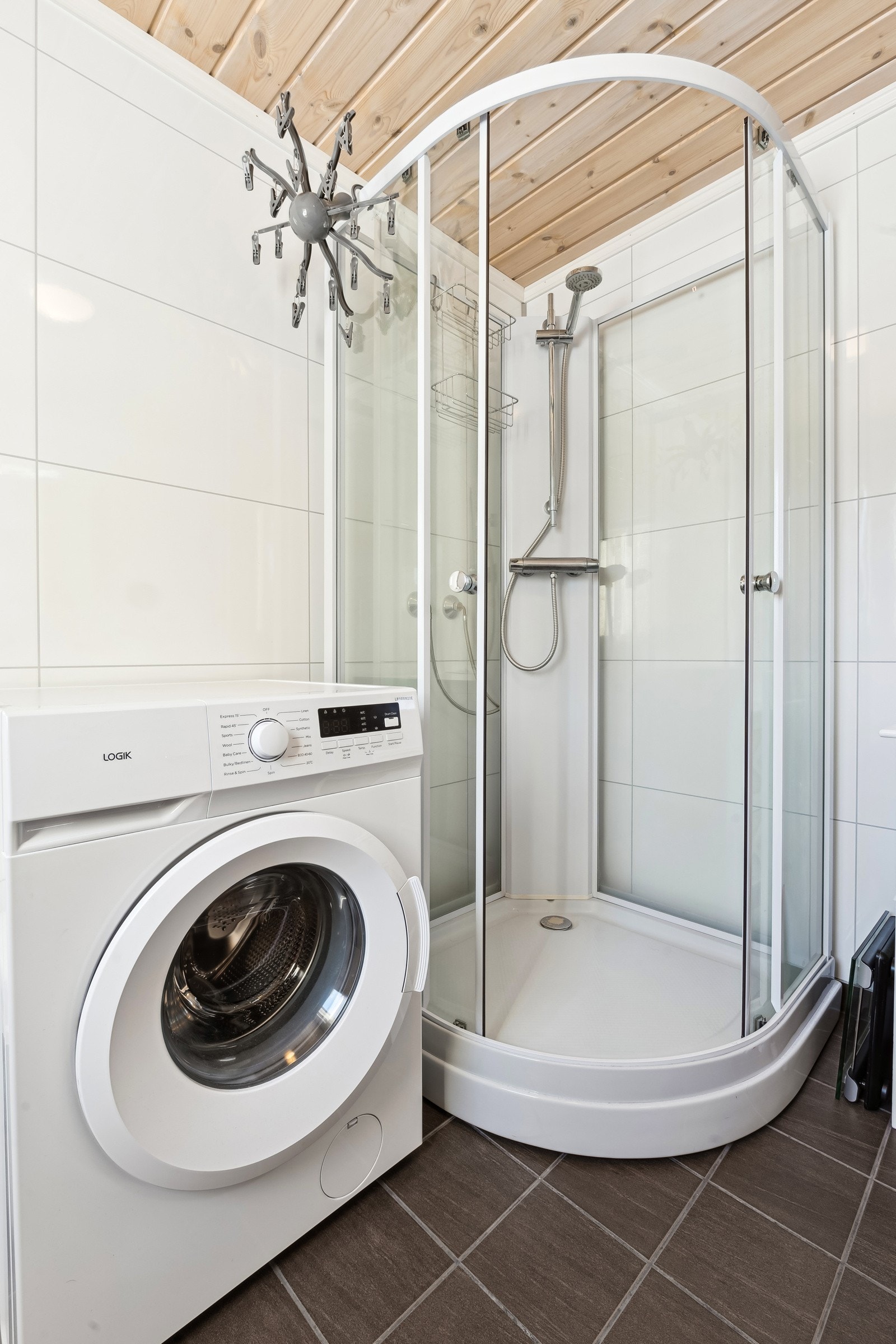 Badet er utstyrt med toalett, servantinnredning og dusjkabinett, samt opplegg for vaskemaskin. Galleribilde