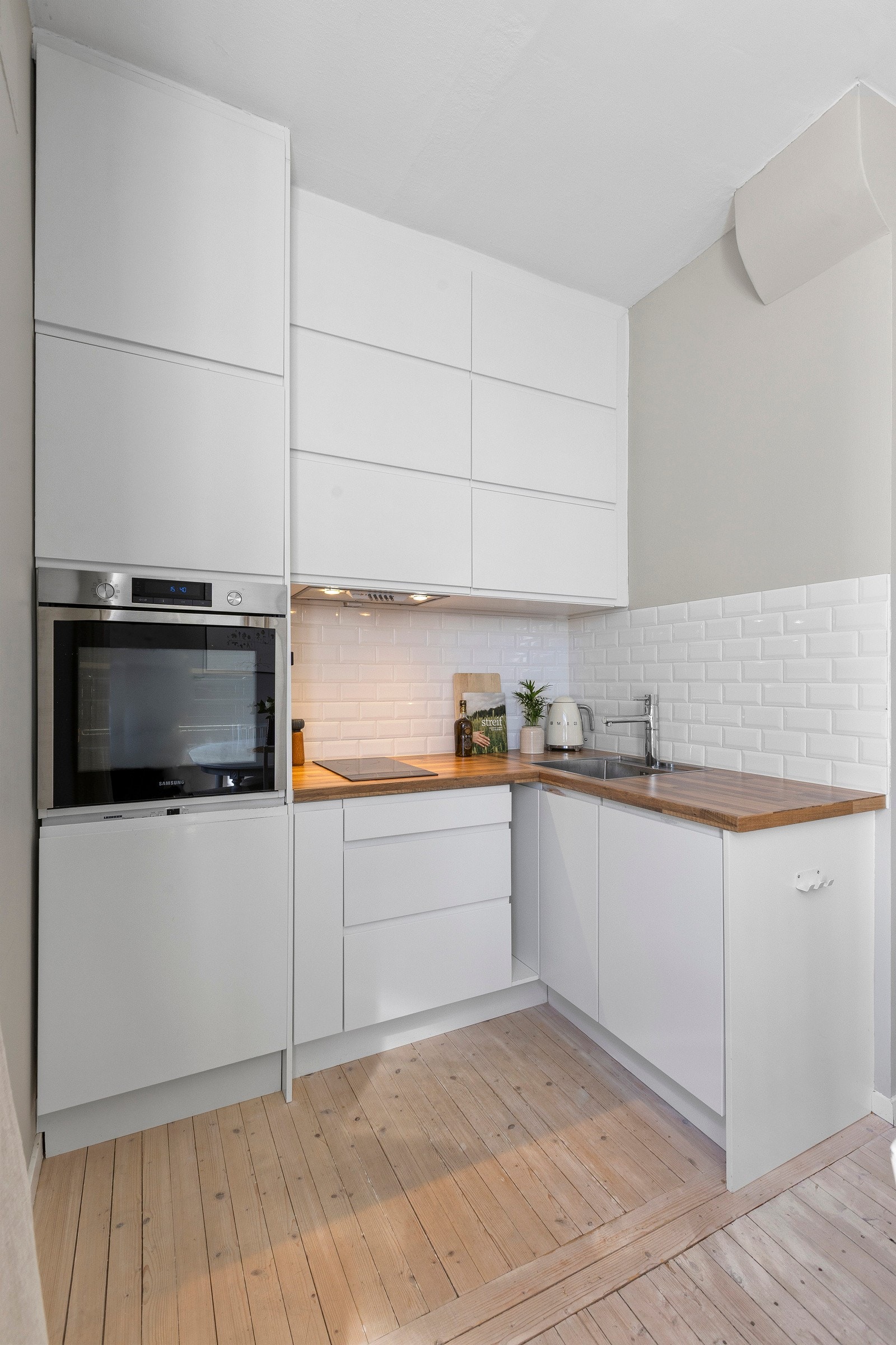 Kjøkkenet har integrerte hvitevarer som komfyr, platetopp, oppvaskmaskin og kjøleskuff. Galleribilde