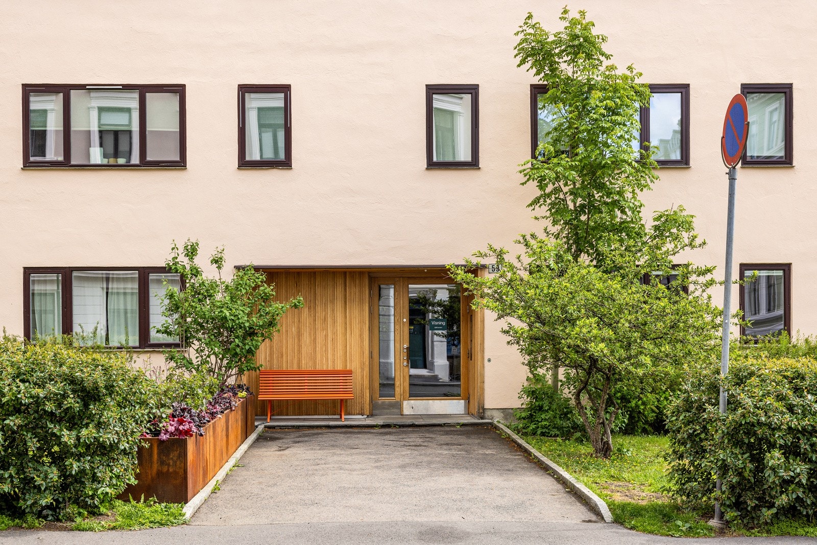 Hyggelig fasade med grønne og sosiale hager foran bygget. Galleribilde