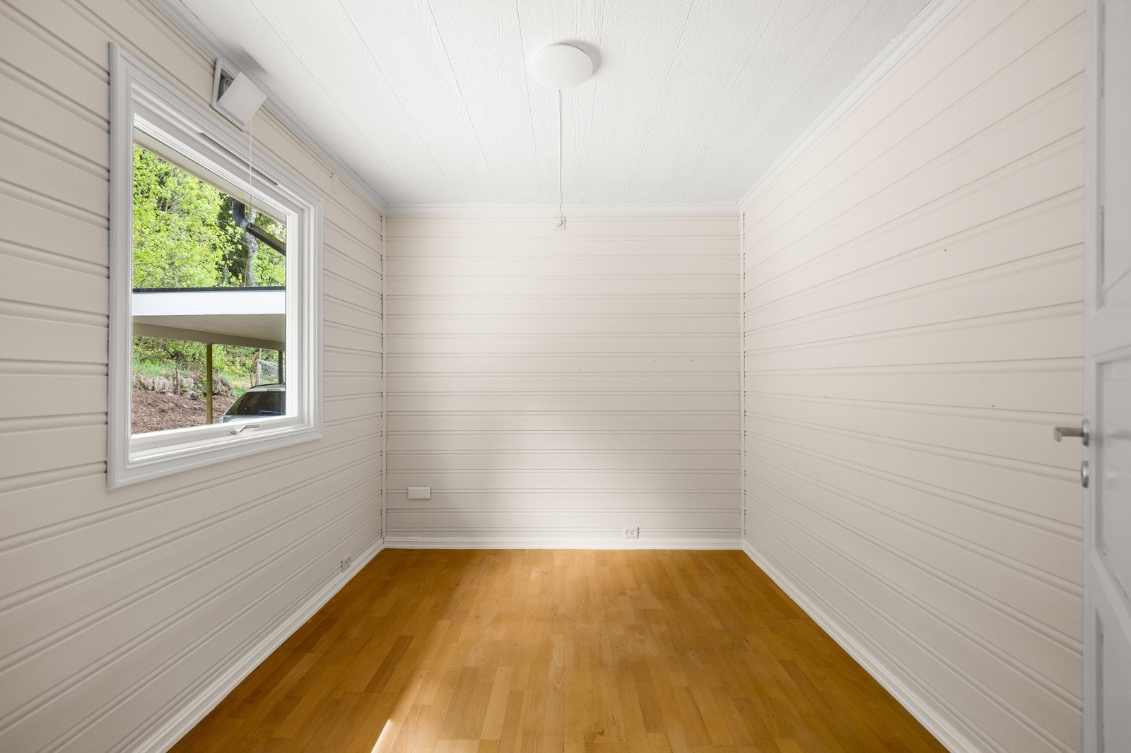 Det ene rommet har adkomst fra bi-inngangen og er utført med lyse overflater i liggende panel. Galleribilde