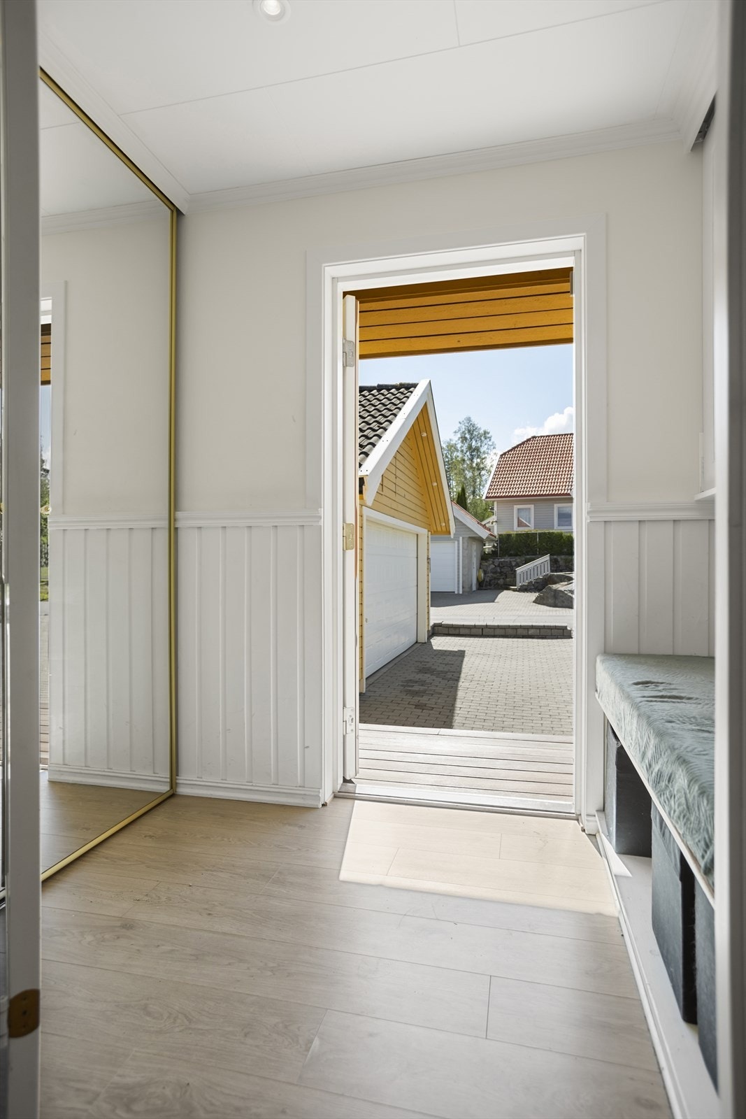 Velkommen inn i en lys og romslig entré med skyvedørsgarderobe samt skyvedører inn mot stuedel Galleribilde