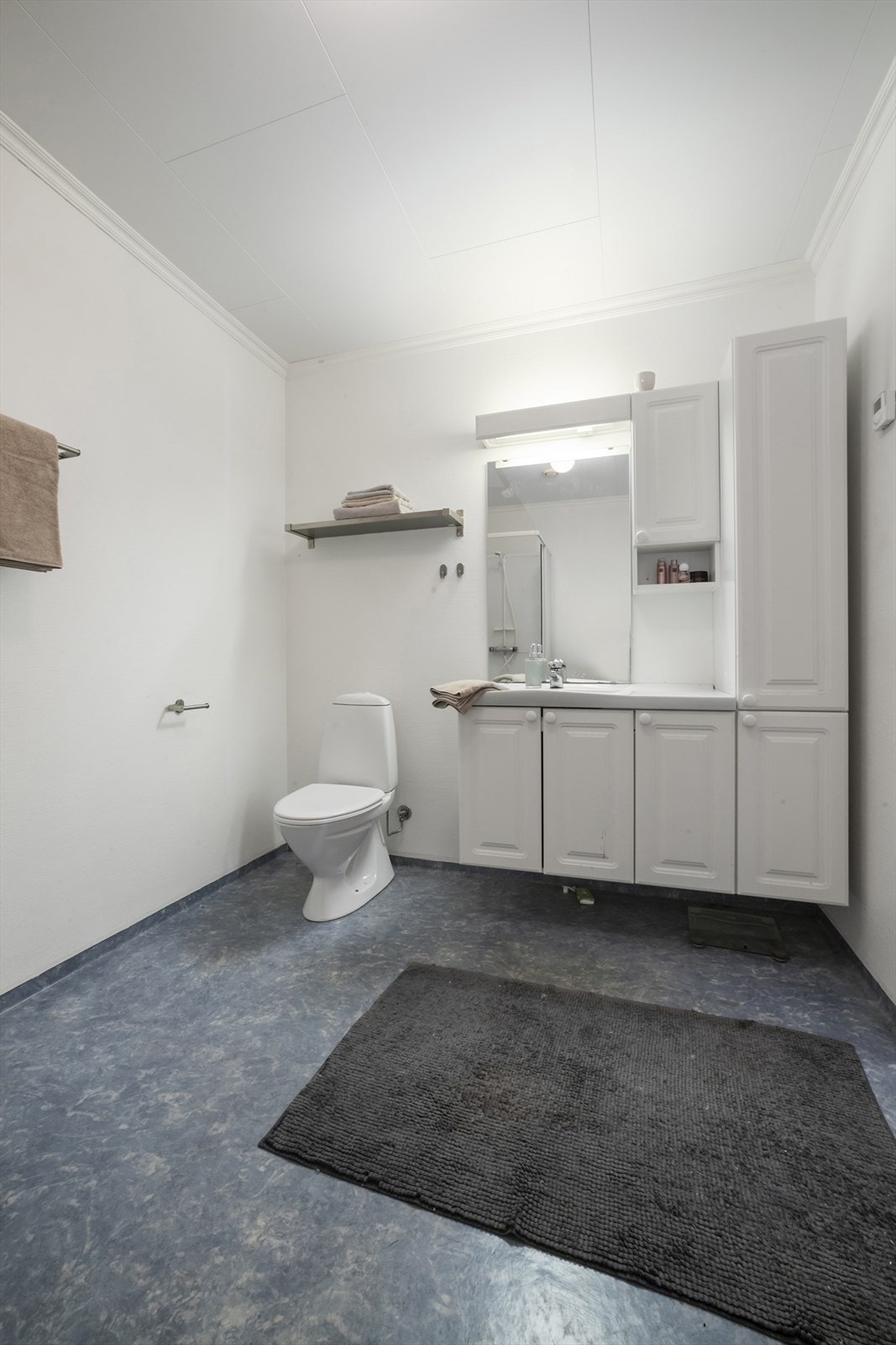 Baderom fra byggeår som har vegger med malt strie og gulv med belegg Galleribilde