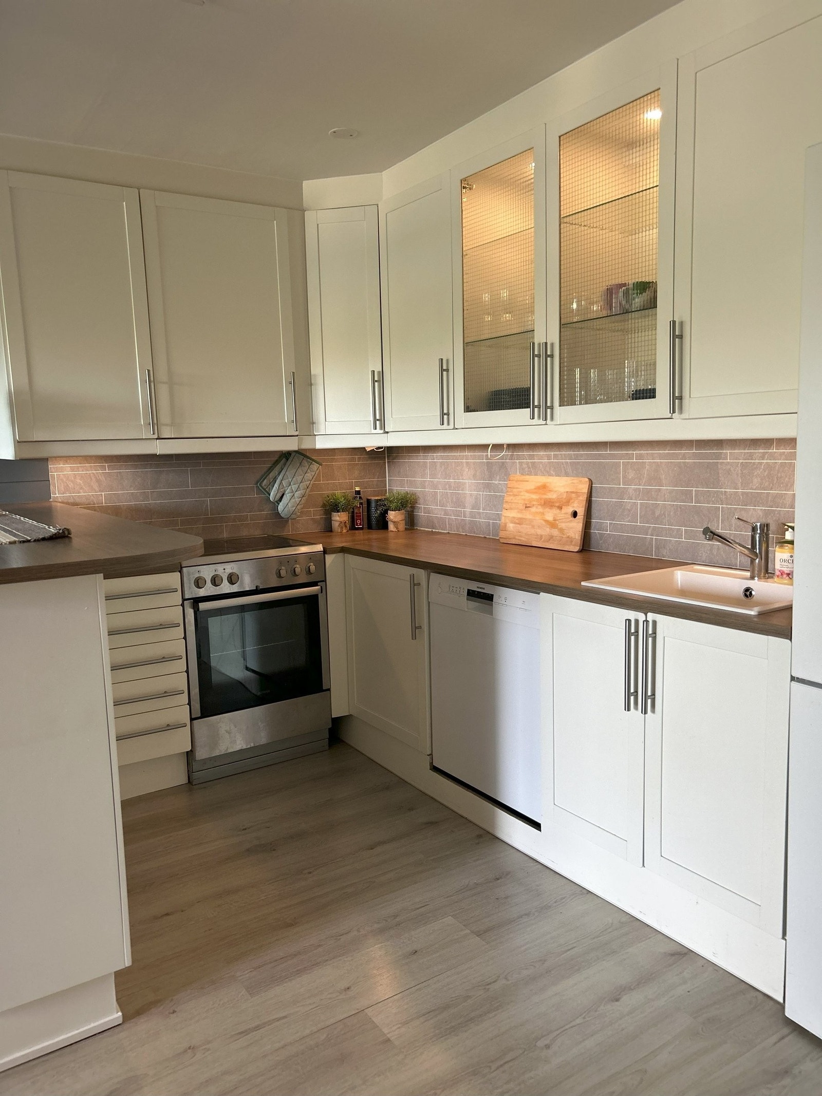 Moderne kjøkken med fine overskap med glassvinduer. Spotter i skap Galleribilde