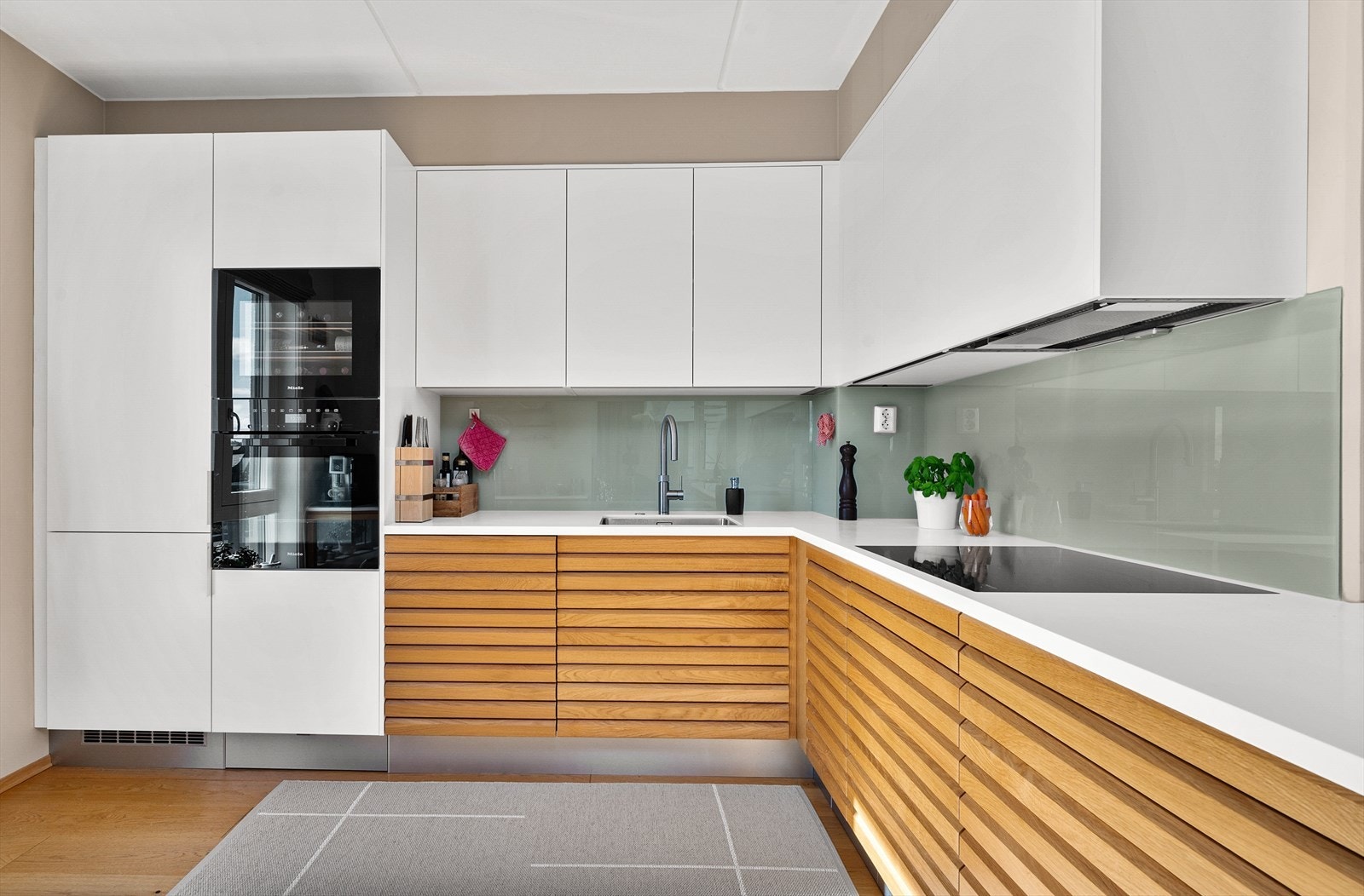 Benkeplate i Corian med underlimt oppvaskkum og Quooker vannkran som gir kokende vann rett i springen. Galleribilde