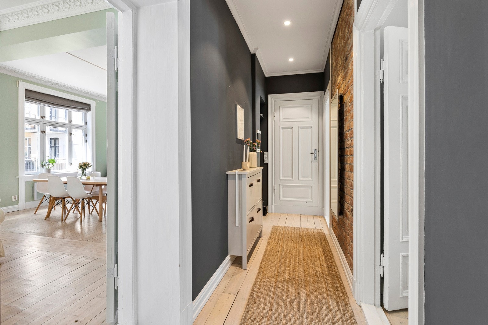 Entréen er innbydende med tregulv og synlig teglstein på vegger, i kominasjon med malte flater. Galleribilde