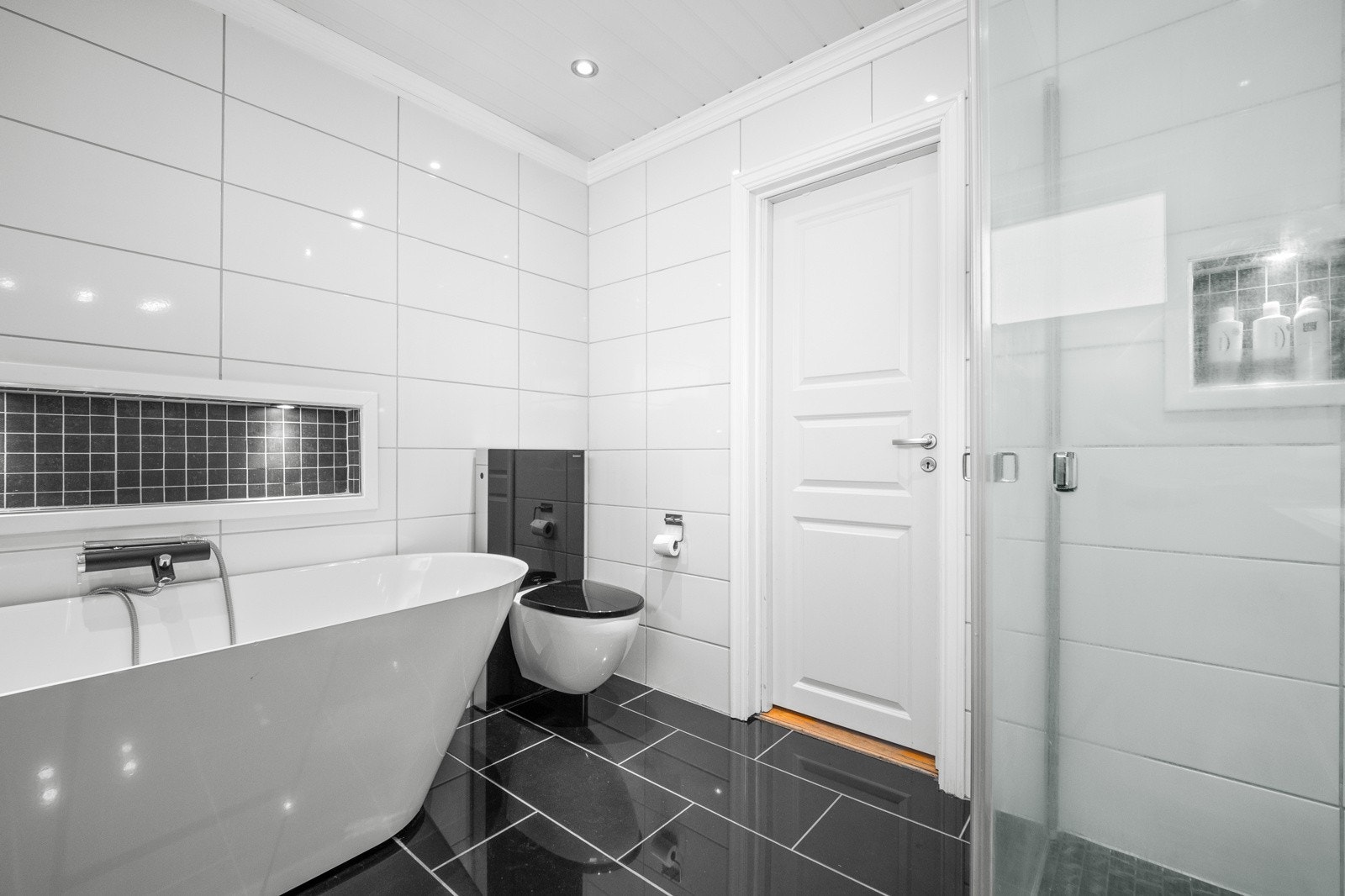 Badet har i tillegg badekar med vegghengt badekararmatur Galleribilde