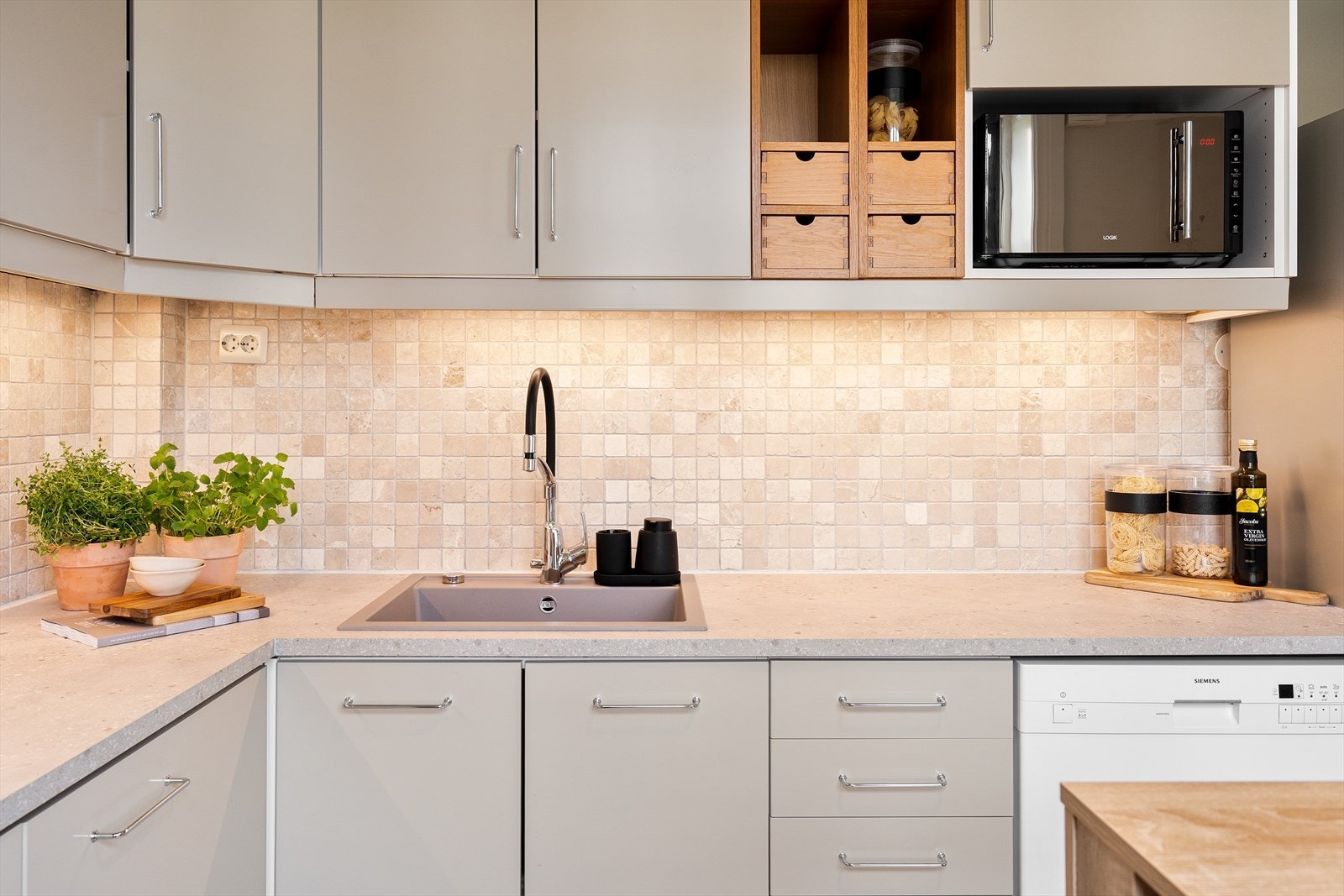 Kjøkkenet har frittstående kjøl/fryseskap og oppvaskmaskin. Integrert ovn med kullfiltervifte over stekesonen. Galleribilde