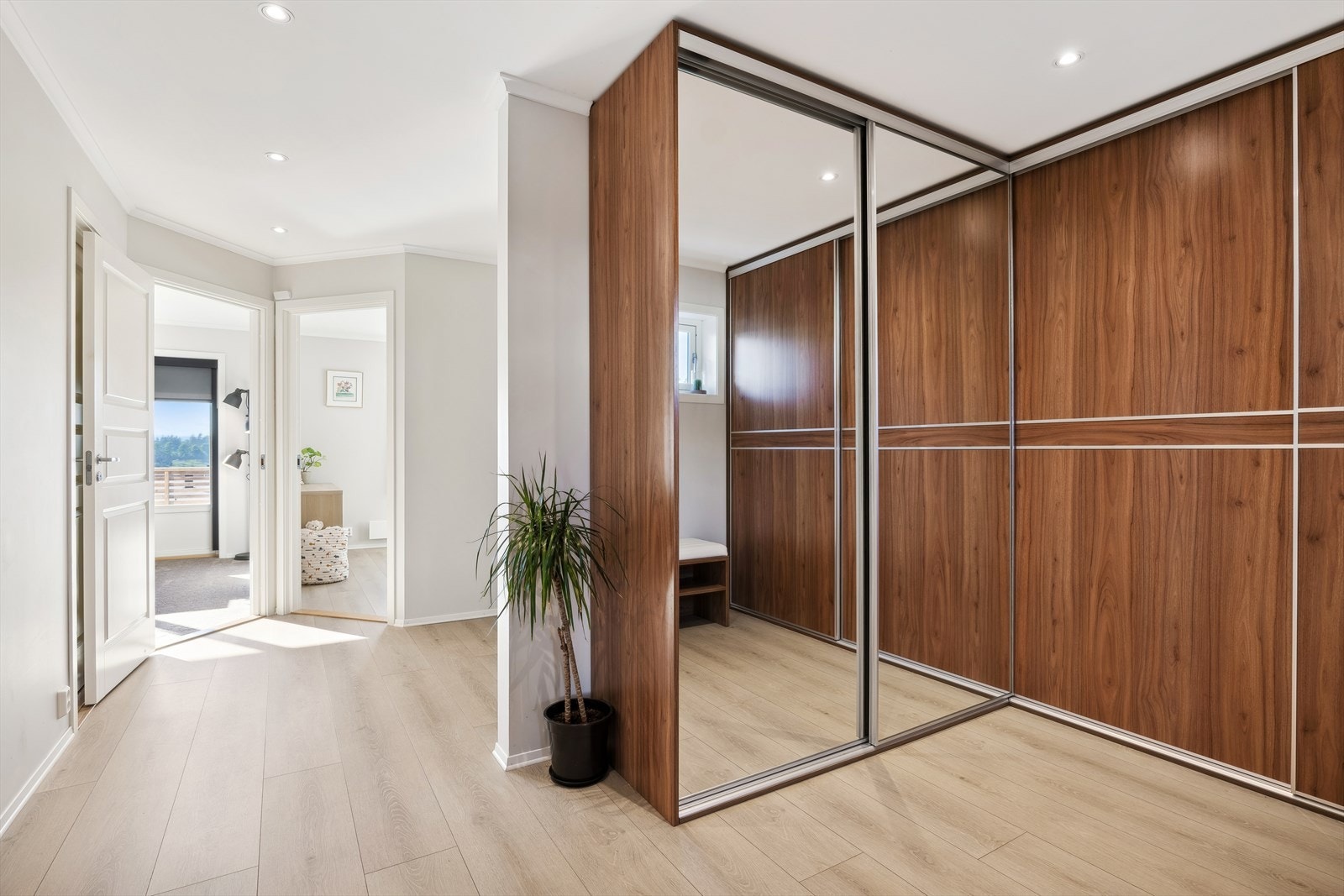Hallen har pen laminat og varmekabler på gulvet. Her er det montert 2 skyvedørsgarderober for god plass til oppbevaring av sko- og yttertøy. Galleribilde