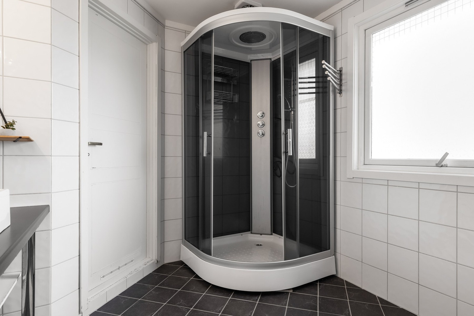 Videre har badet et dusjkabinett med to-greps blandebatteri, takdusj og hånddusj Galleribilde