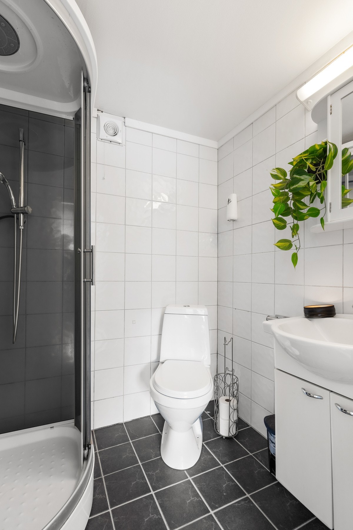 Bad med adkomst fra soverom med flislagt gulv og vegger med en kombinasjon og fliser og baderomsplater Galleribilde