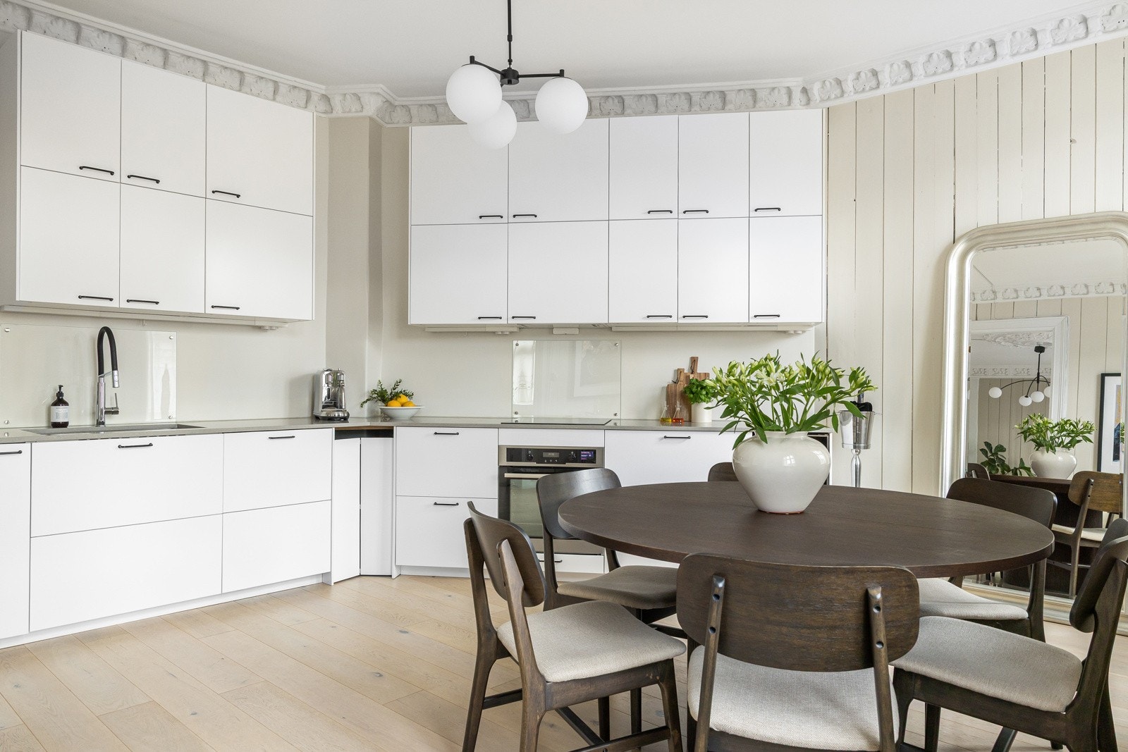 Kjøkkenet har glatte, fabrikklakkerte fronter og benkeplate i stein med underlimt kum i rustfritt stål. Galleribilde