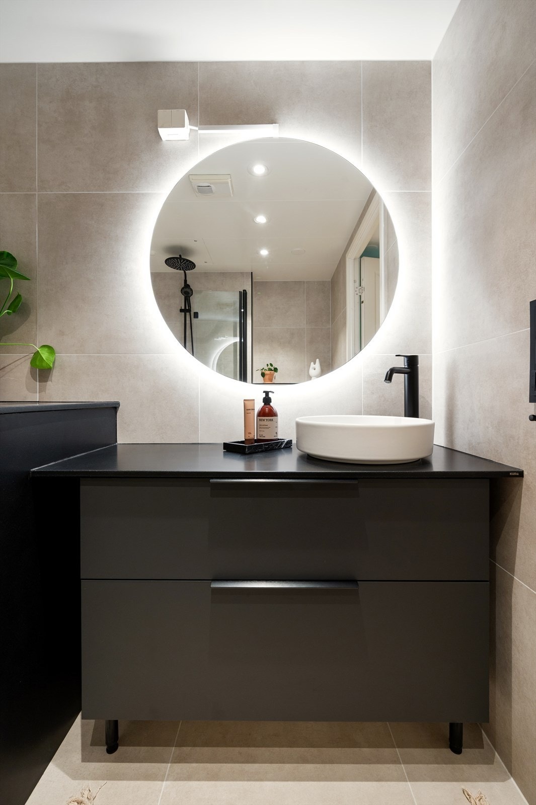 Rommet har varmekabler i gulvet og inneholder servant på underskap, speil med belysning, vegghengt toalett og dusjhjørne med dusjvegger i herdet glass. Galleribilde