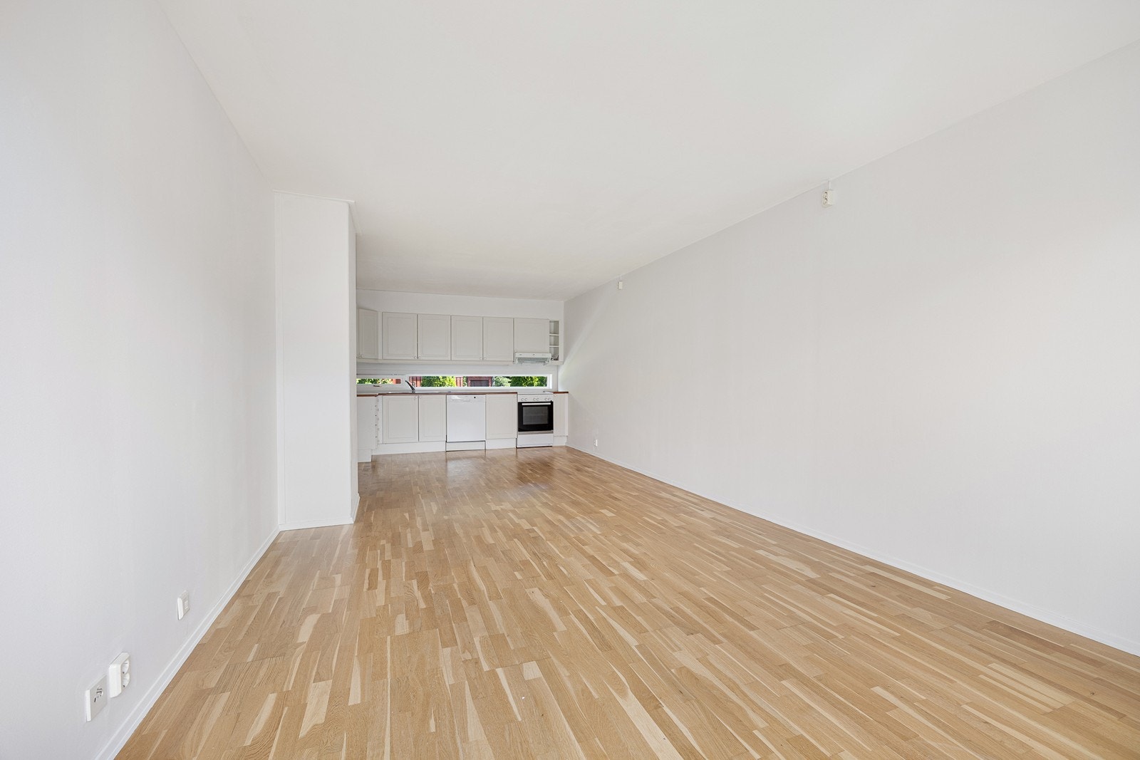 På gulvet har allrommet parkett, mens veggflatene er hvitmalte. Galleribilde