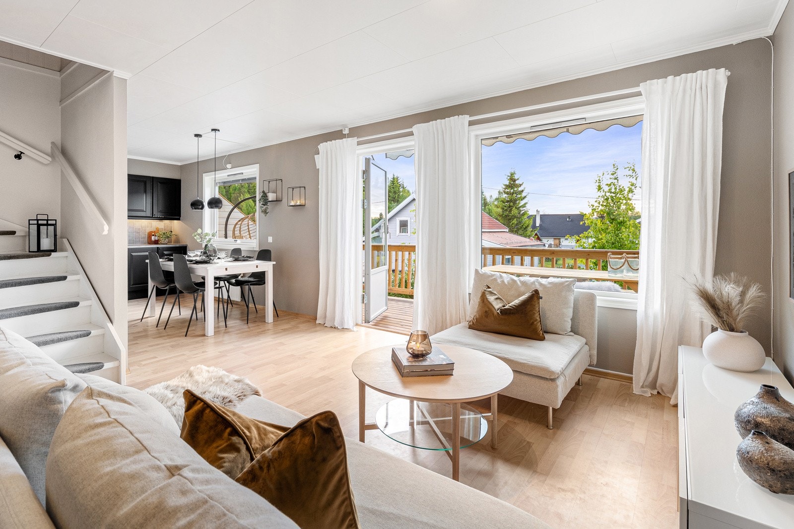 Stuen fremstår som meget innbydende i en dus og delikat fargepalett. Gode vindusflater slipper inn rikelig med lys og gir en luftig romfølelse. Galleribilde