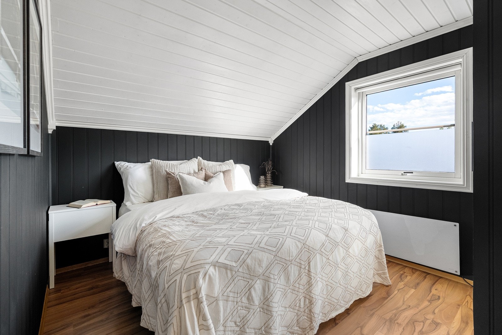 Hovedsoverommet er hendig plassert i boligens loftsetasje og har "suite-løsning" med et eget tilhørende baderom. Rommet fremstår som meget innbydende med malt smartpanel på veggflater, laminat på gulv og et stort vindu som slipper inn rikelig med lys. Galleribilde