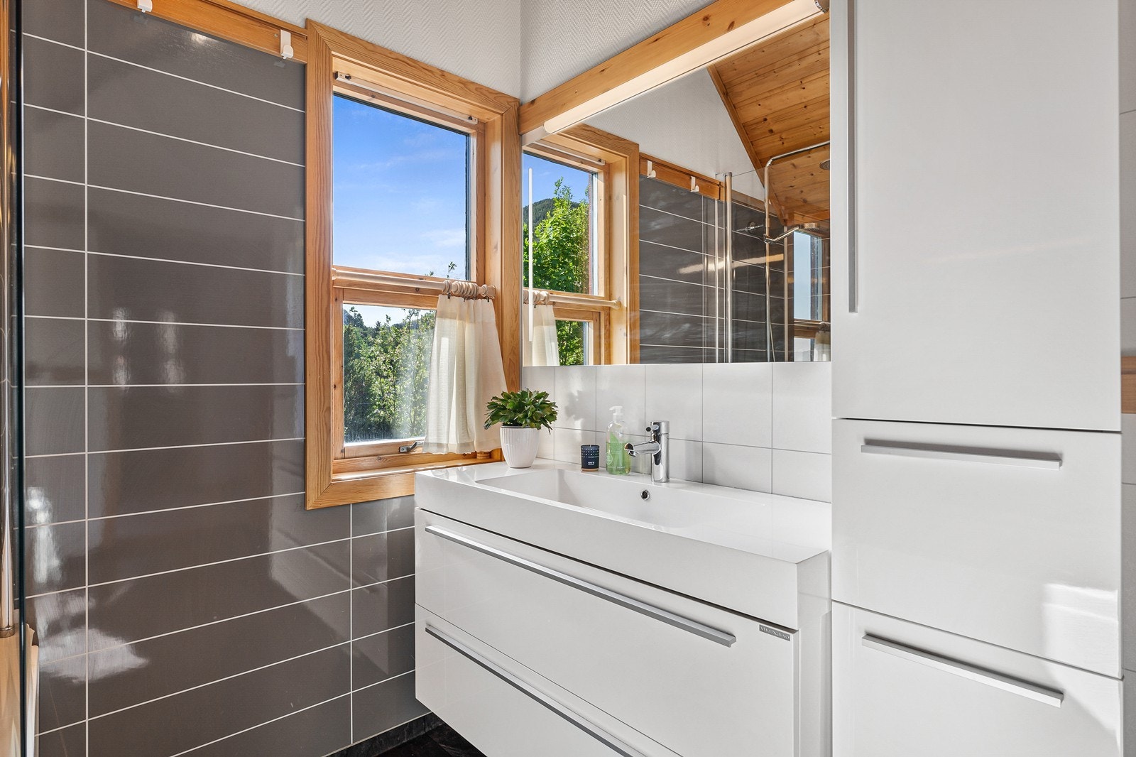 Badet er innredet med badekar, baderomsinnredning med vask og toalett. Galleribilde