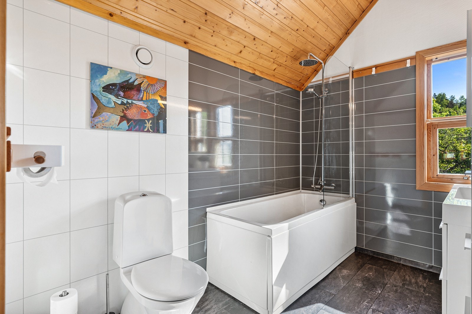 Badet på loftet har gulvbelegg med varmekabler, baderomsplater på vegger og panel i himlingen. Galleribilde