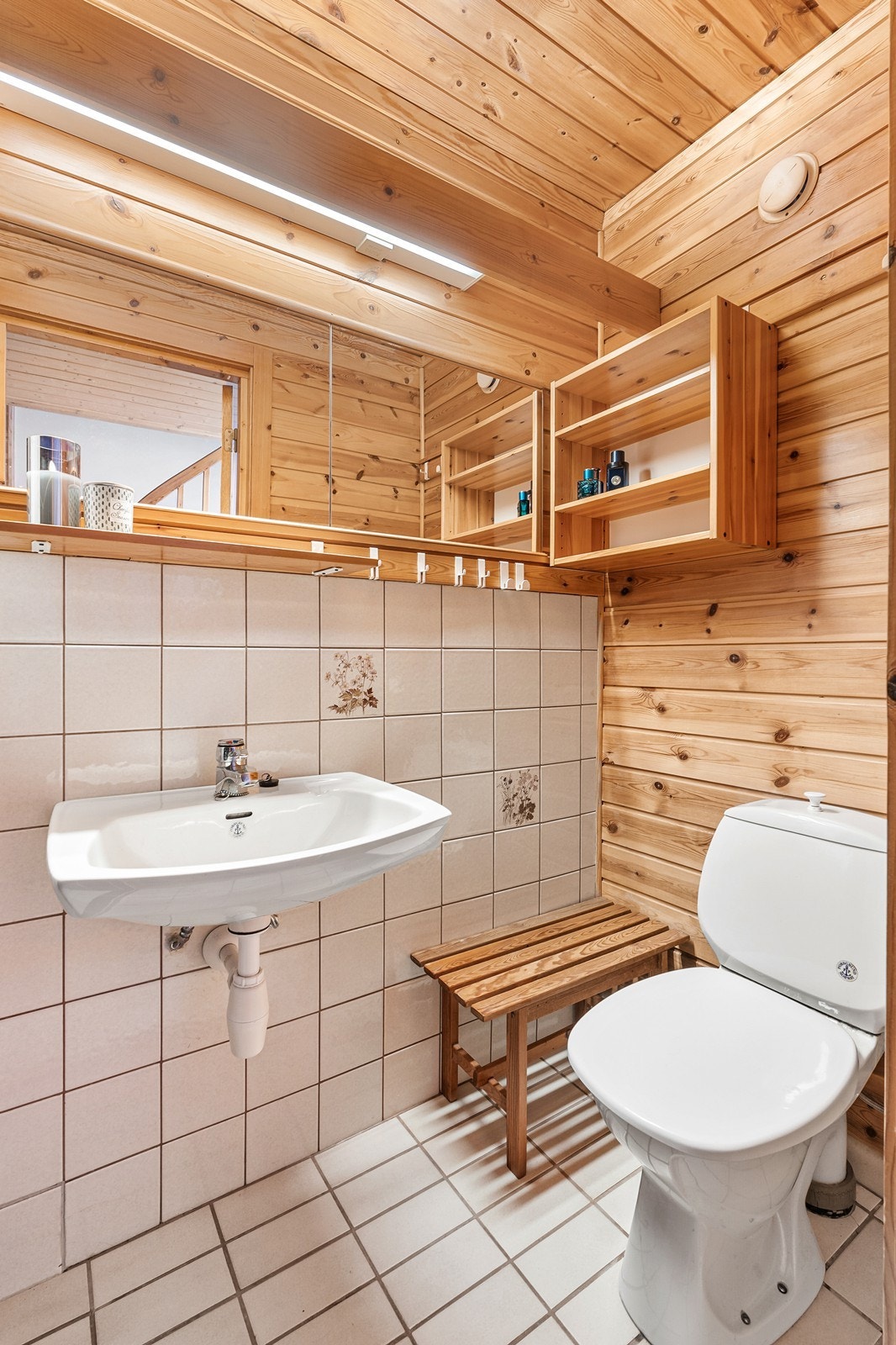 Badet i kjelleren har gulvfliser med varmekabler, fliser på vegger i dusjsonen og panel i taket. Galleribilde