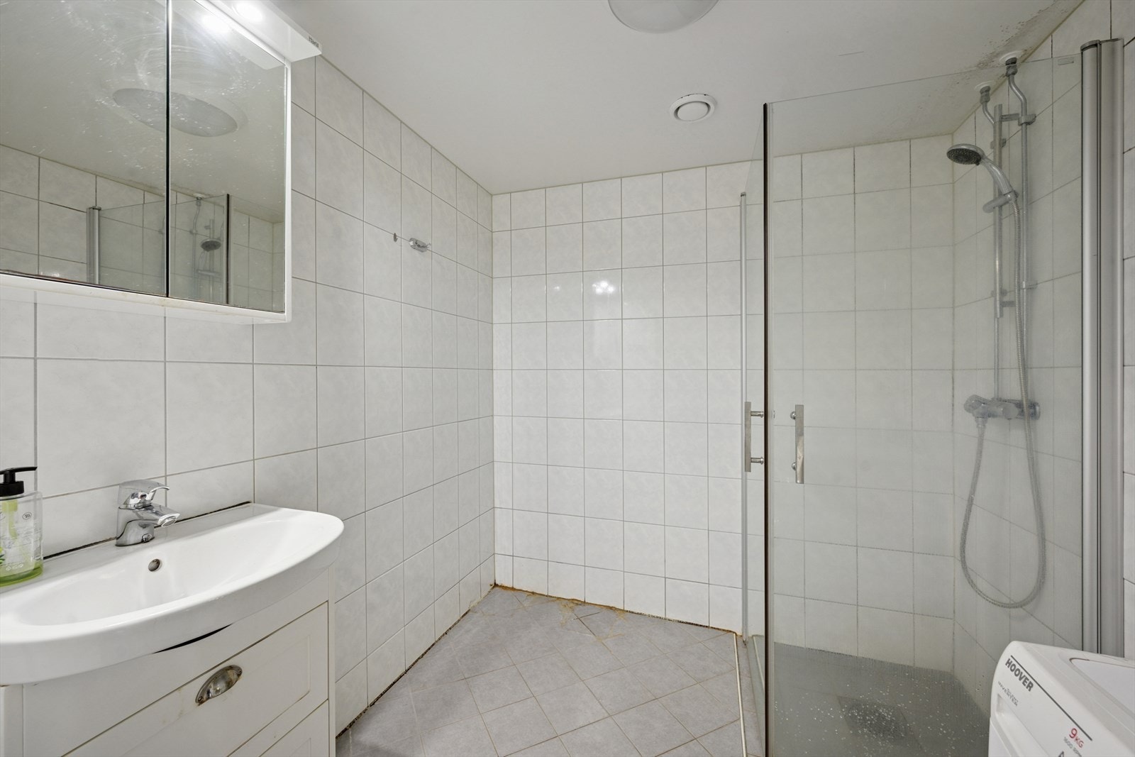 Flislagt bad i regi av borettslaget, med dusjhjørne, servant med innredning og opplegg til vaskemaskin. Galleribilde