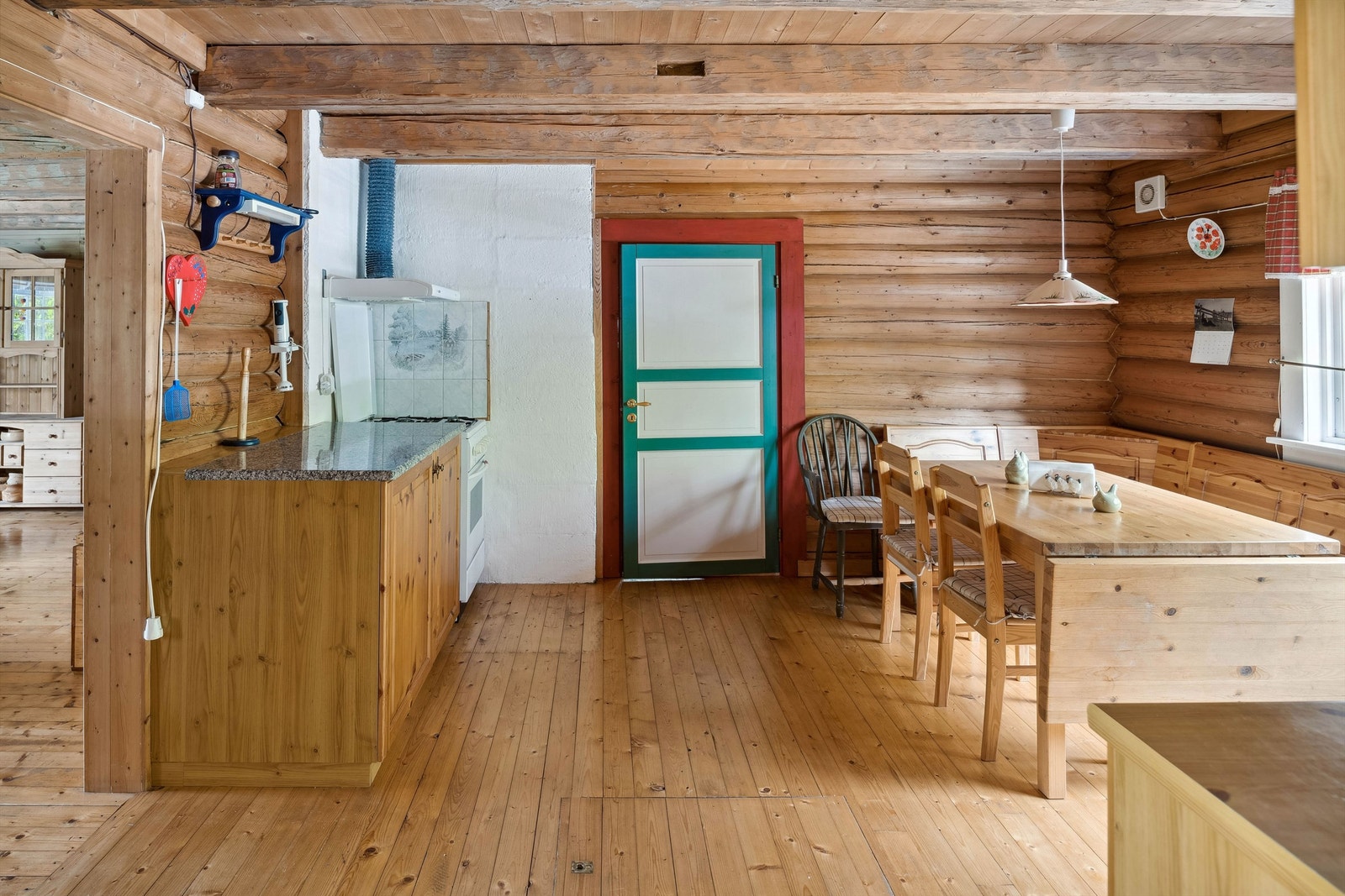 Romslig kjøkken med tregulv og tømmervegger. Også her synlige åser i taket Galleribilde