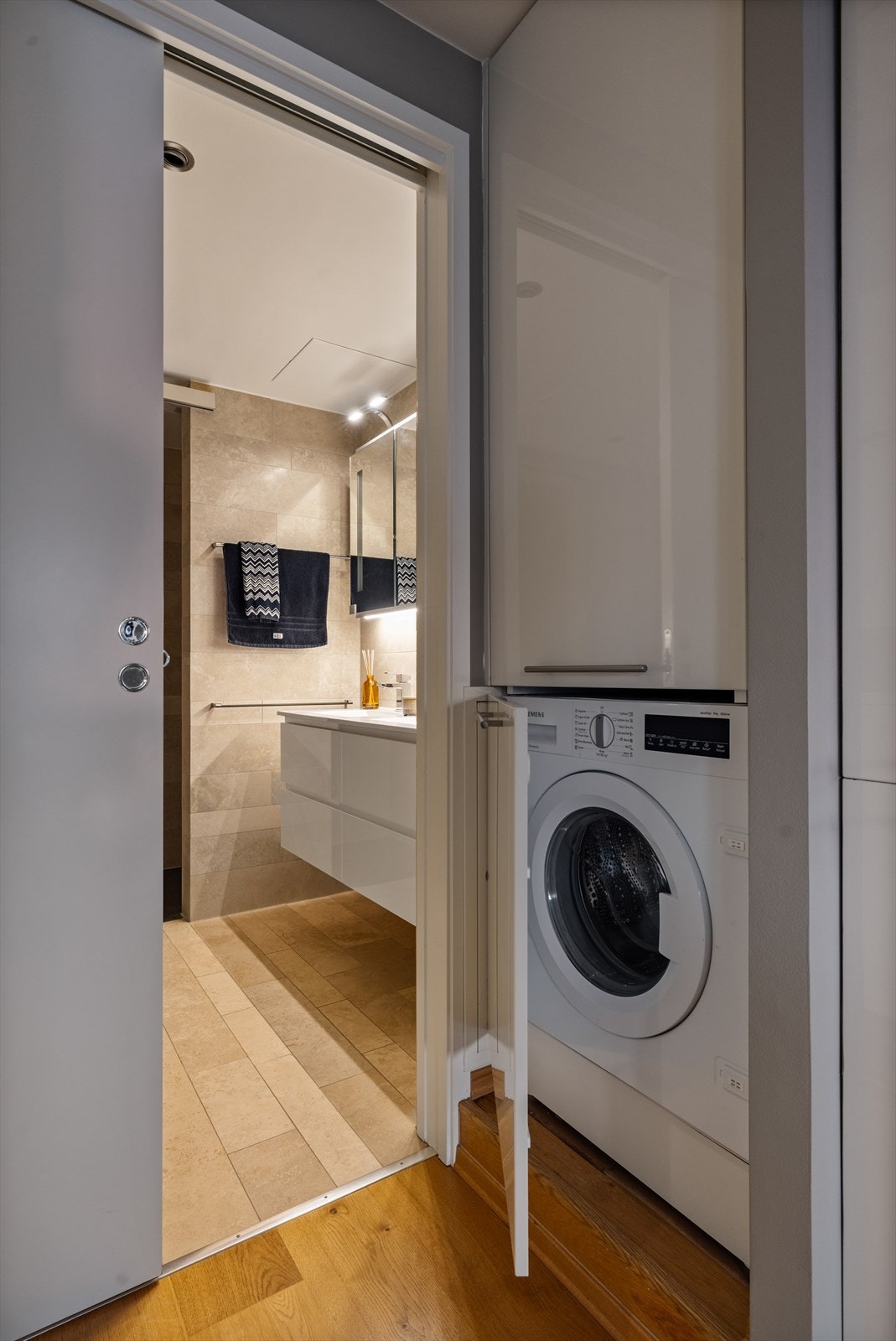 Ved inngangen til badet er det eget skap til vaskemaskin. Galleribilde