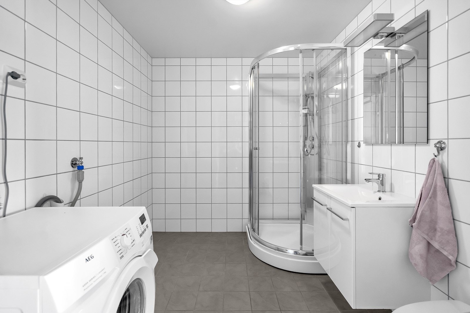 Bad 2 utstyrt med dusjkabinett, servant, toalett og opplegg for vaskemaskin. Galleribilde