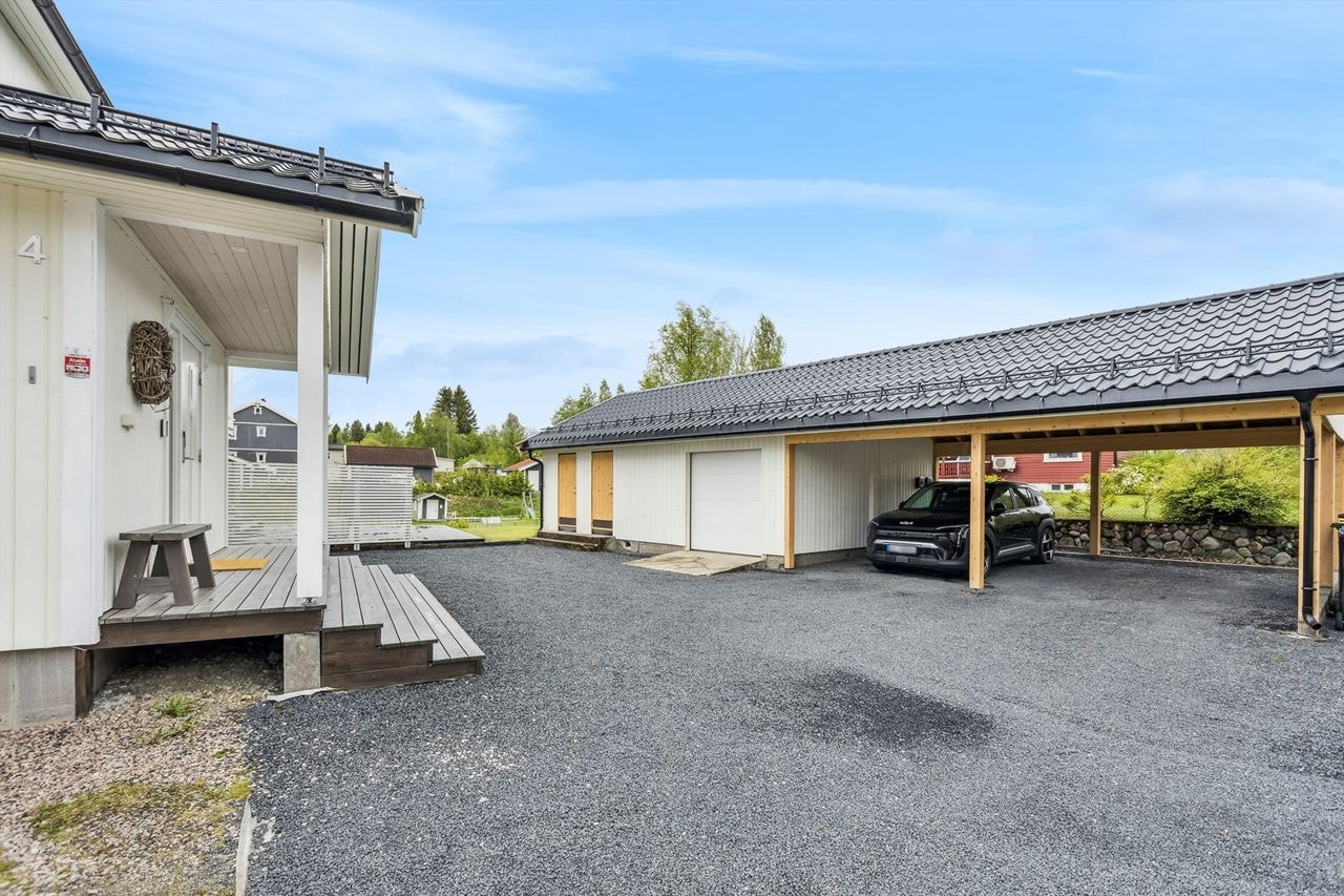 Det er garasje med inntilbygget carport med plass til to biler i tillegg til boder Galleribilde