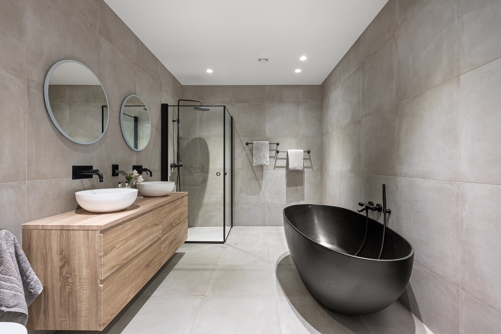 Rommet har innredning med 2 servanter, veggmontert toalett, badekar, dusjvegger/hjørne. Galleribilde