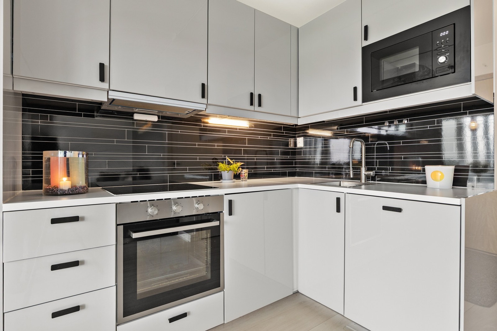 Innredningen har glatte fronter, som gir et stilrent uttrykk, mens benkeplaten er laget av slitesterkt laminat. Det er også en kjøkkenventilator med kullfilter, som bidrar til et godt inneklima. Galleribilde