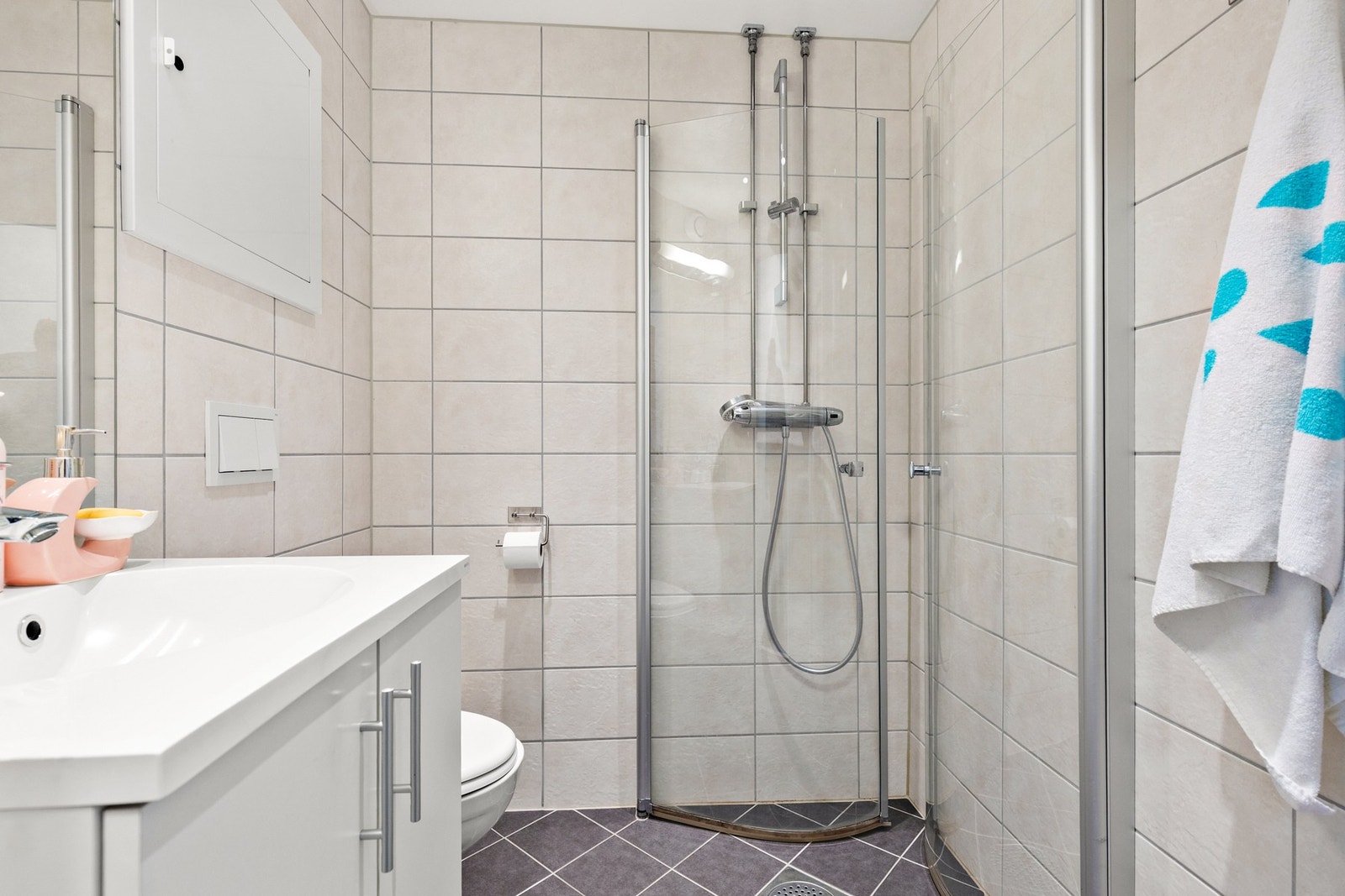 Badet er moderne og kompakt, med fliser på både gulv og vegger. Galleribilde