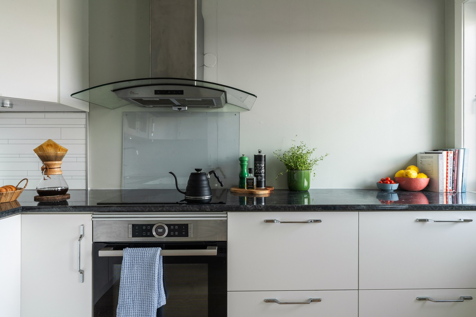 Kitchenboard på vegg over benk og belysning under overskap.